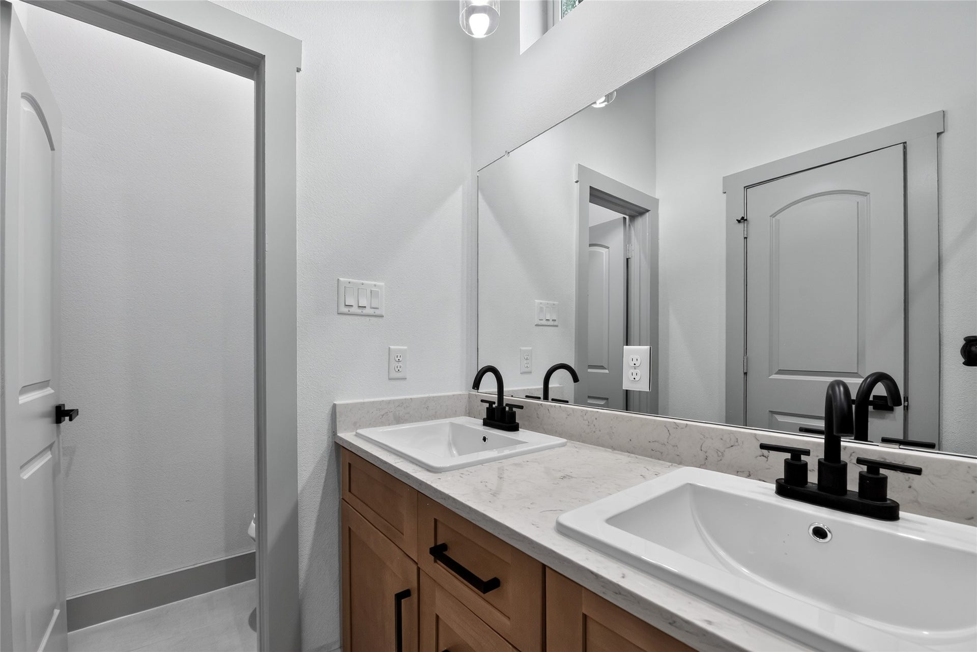 6815 Stearns Street, Houston, TX 77021 A spa-like retreat designed for effortless routines features custom artisan cabinetry that provides thoughtful storage and pairs seamlessly with dual sinks and refined fixtures for a balanced blend of everyday functionality and timeless elegance.