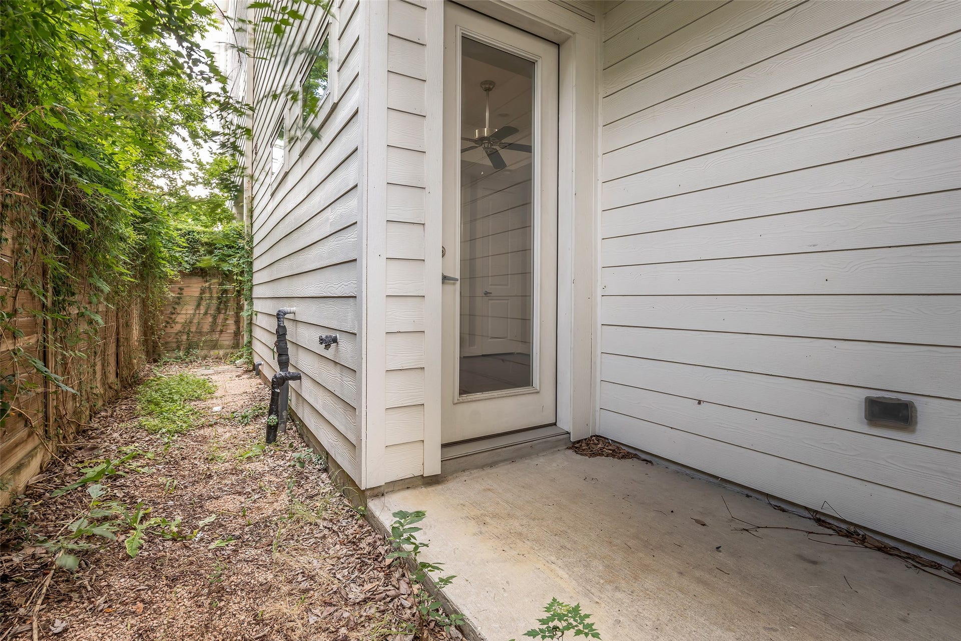 3309 Jefferson Street, #C, Houston, TX 77003 Back door on the first floor opening to a small covered patio, with additional outdoor space that can be used for various purposes such as seating, storage, or future enhancements.