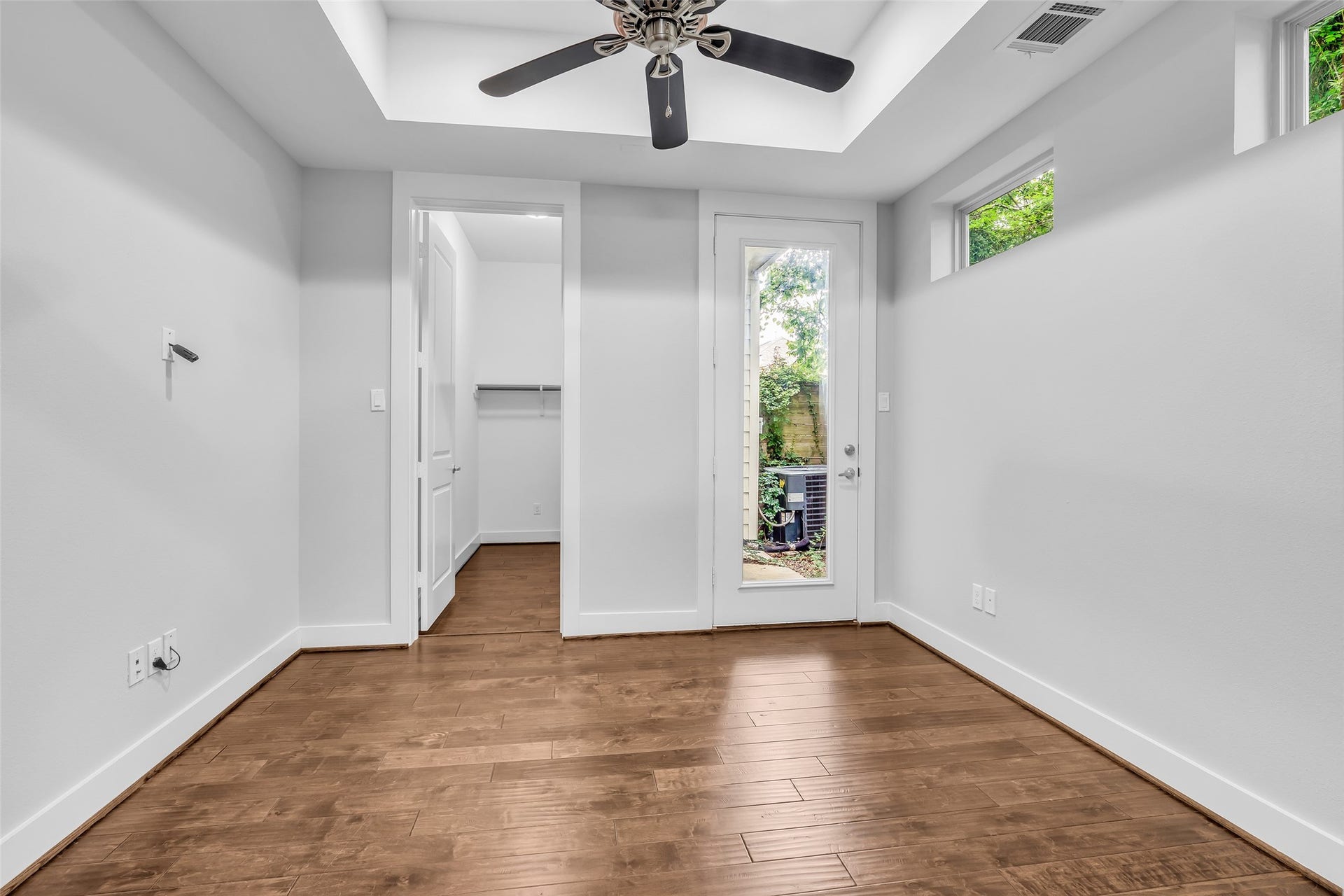 3309 Jefferson Street, #C, Houston, TX 77003 First-floor bedroom featuring a tray ceiling, vinyl plank flooring, and ample natural light.