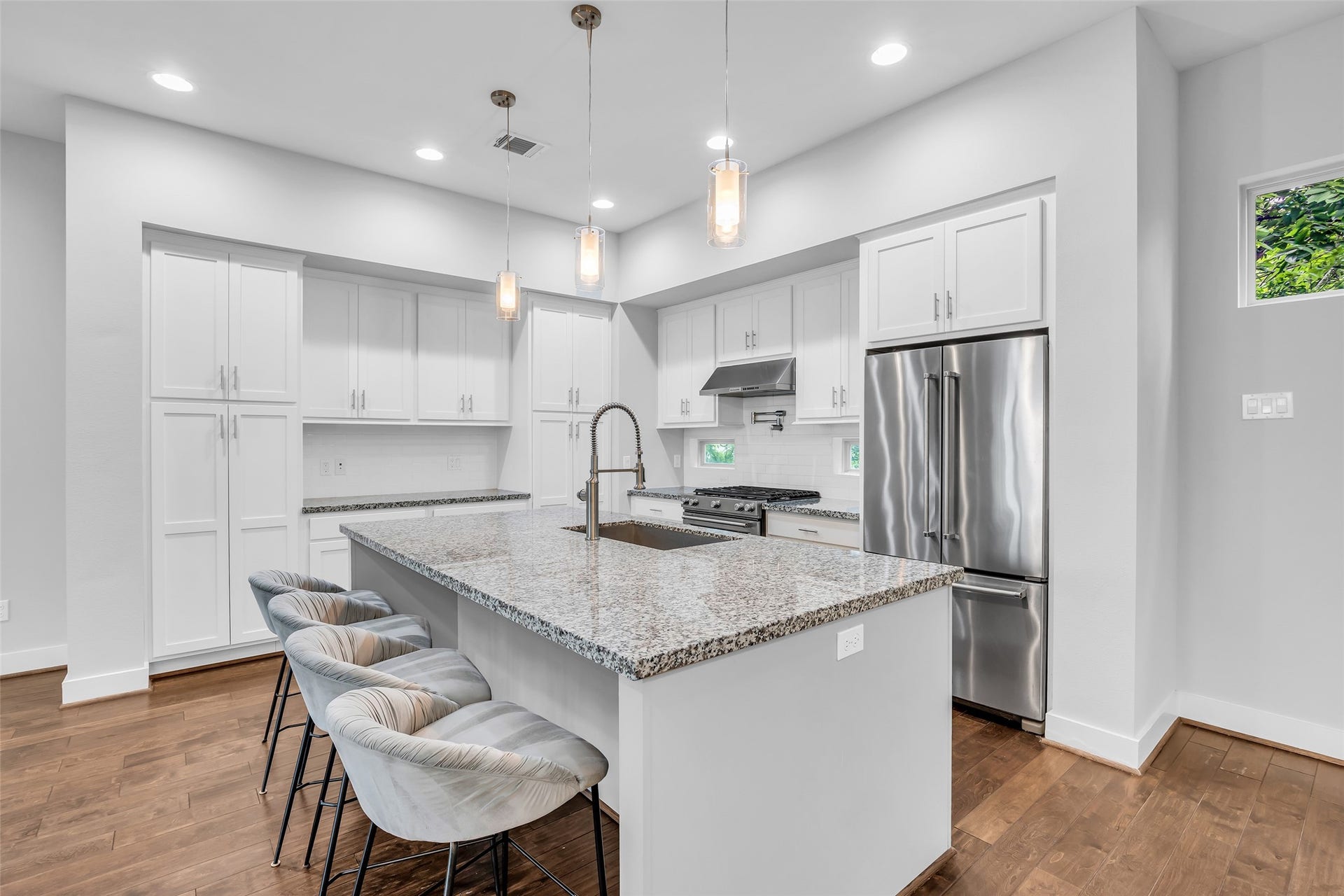 3309 Jefferson Street, #C, Houston, TX 77003 View of the kitchen highlighting its layout, including the central island and surrounding cabinetry, designed for efficient workflow and easy movement throughout the space.