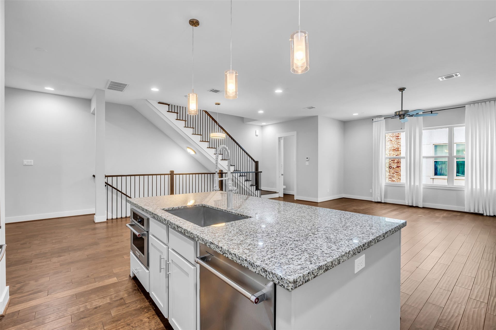3309 Jefferson Street, #C, Houston, TX 77003 Corner view of the kitchen showing the living room at the front, along with the staircase that connects the first, second, and third floors. The layout emphasizes open sightlines and easy movement throughout the home.