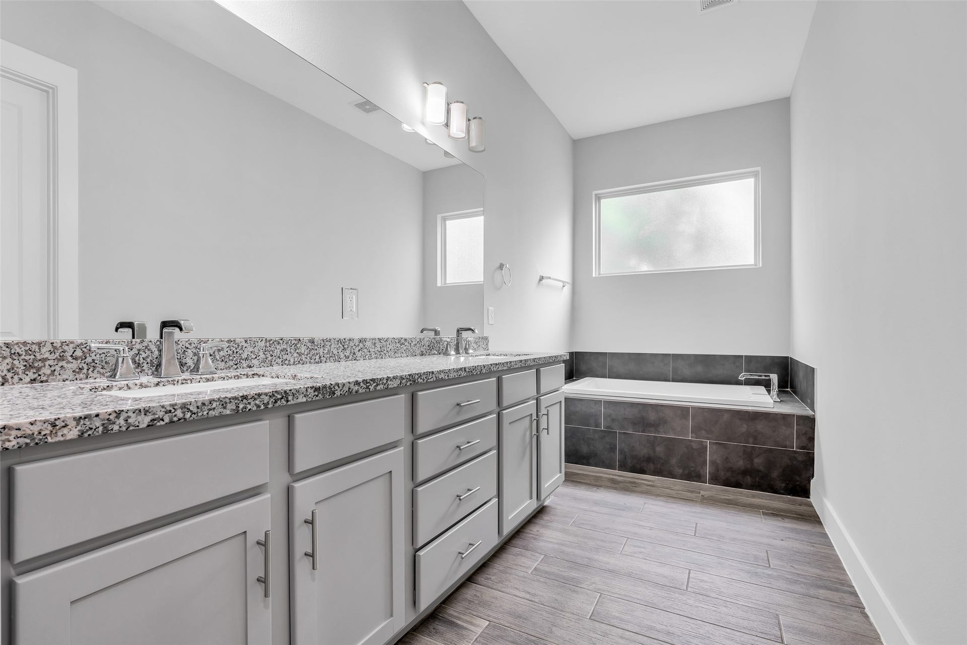 3309 Jefferson Street, #C, Houston, TX 77003 Primary bathroom with a modern design featuring granite countertops, dual sinks, and a combined tub and shower, offering a clean and functional layout for everyday comfort.