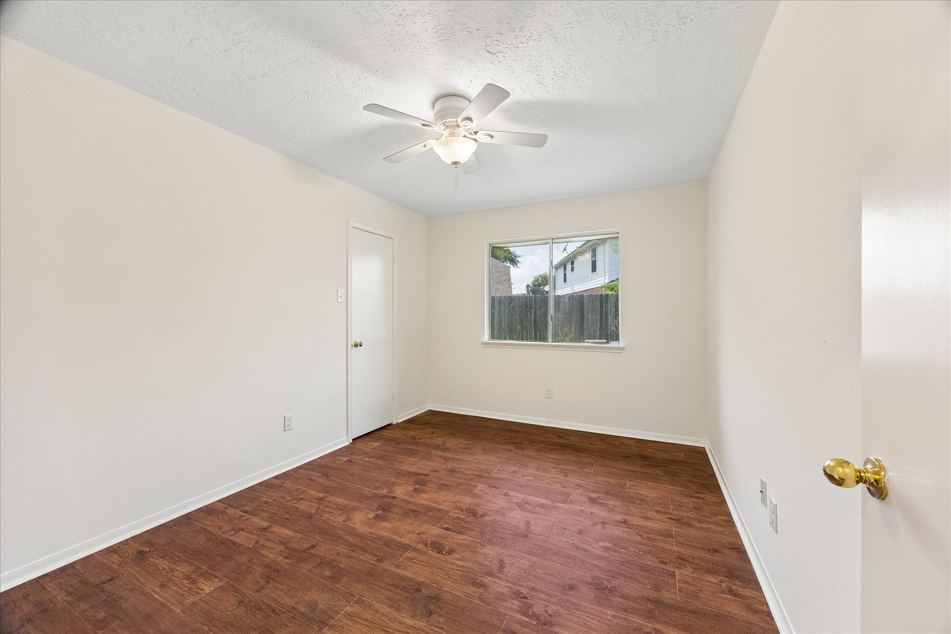 3806 Crystal Falls Drive, Missouri City, TX 77459 Comfortable secondary bedroom featuring warm wood flooring, a ceiling fan, and a large window overlooking the exterior.