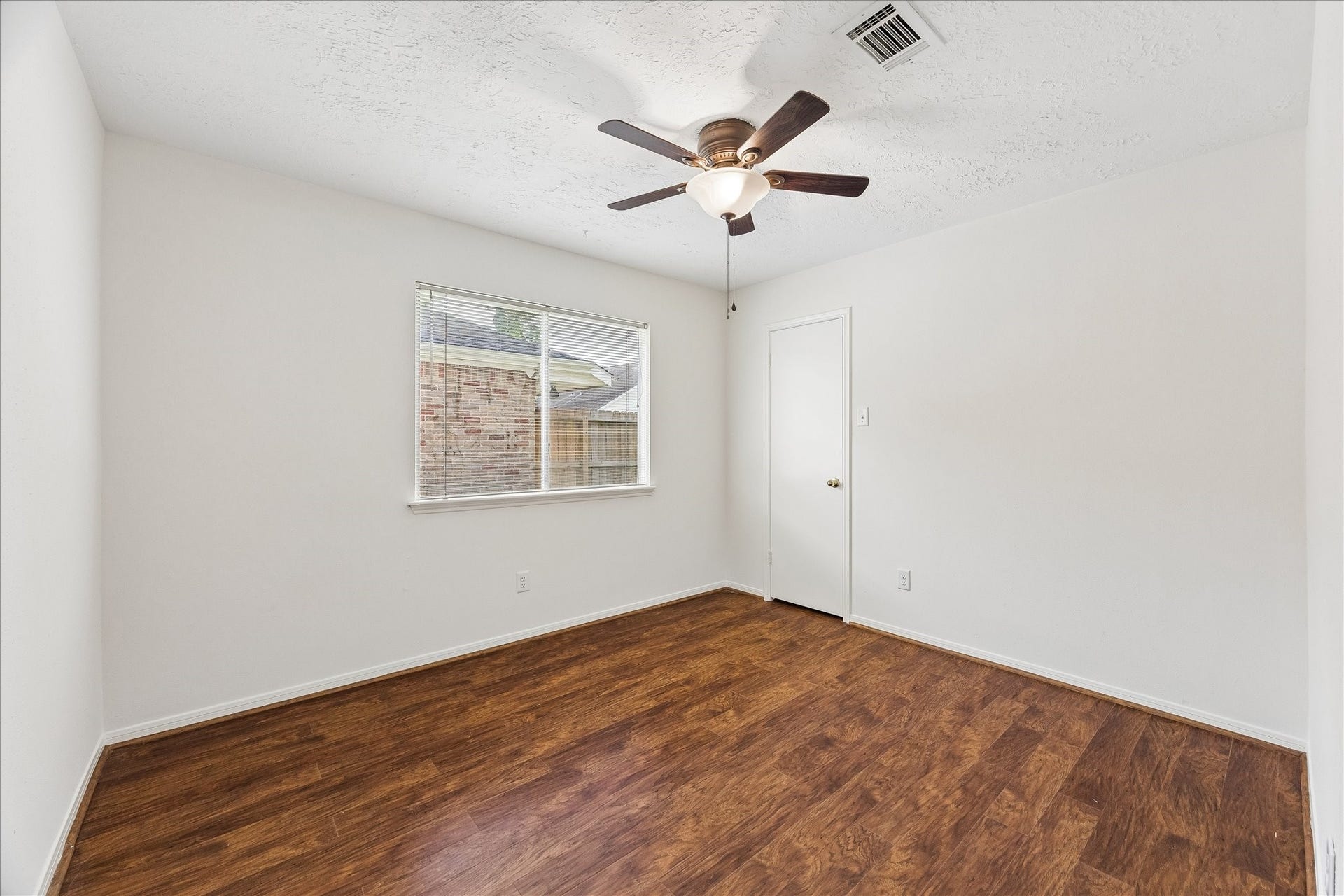 3806 Crystal Falls Drive, Missouri City, TX 77459 Bright secondary bedroom with wood flooring, ceiling fan, ample natural light, and neutral finishes.
