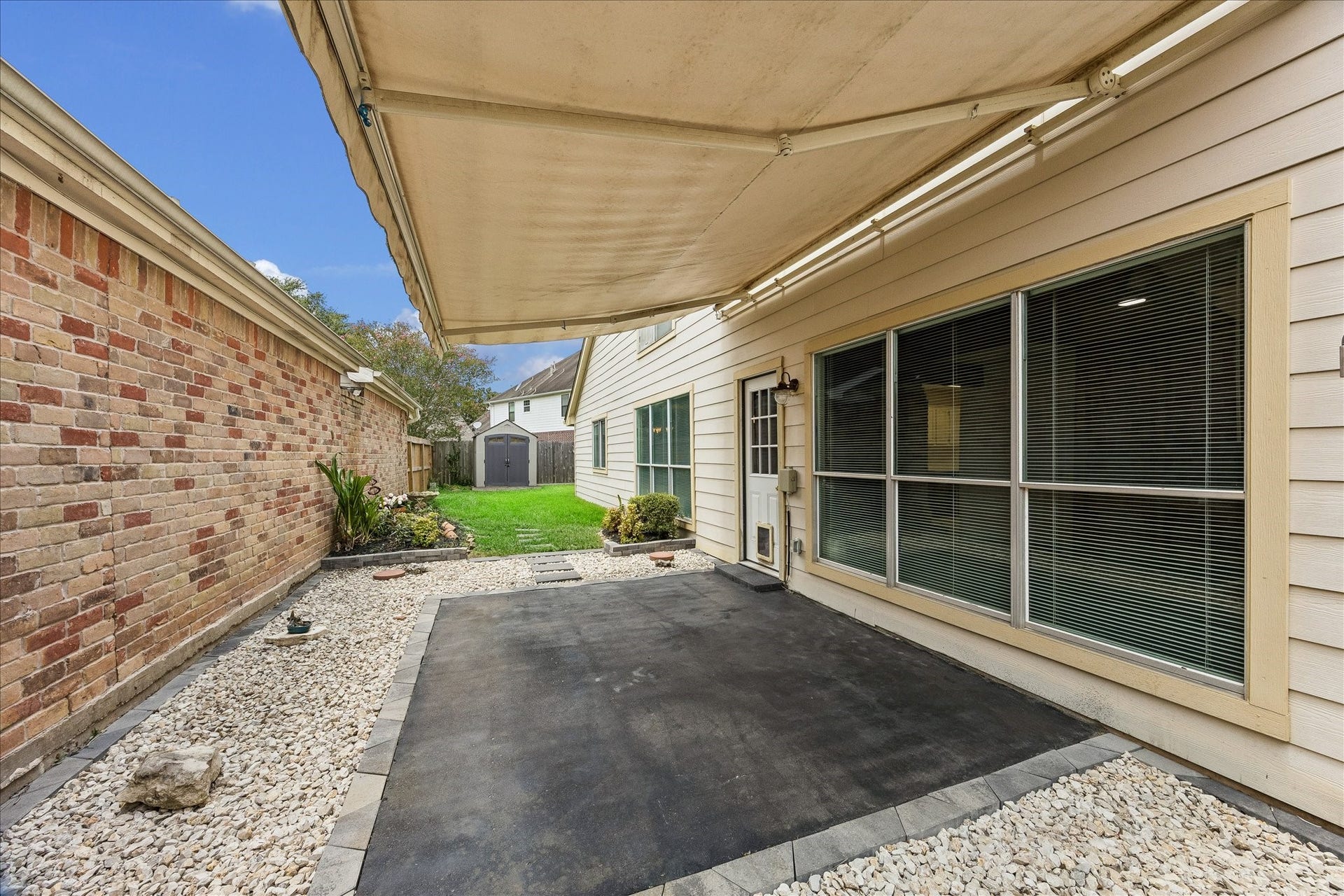 3806 Crystal Falls Drive, Missouri City, TX 77459 Covered outdoor living area with a retractable awning overlooks the backyard and provides a shaded space for relaxing or entertaining.