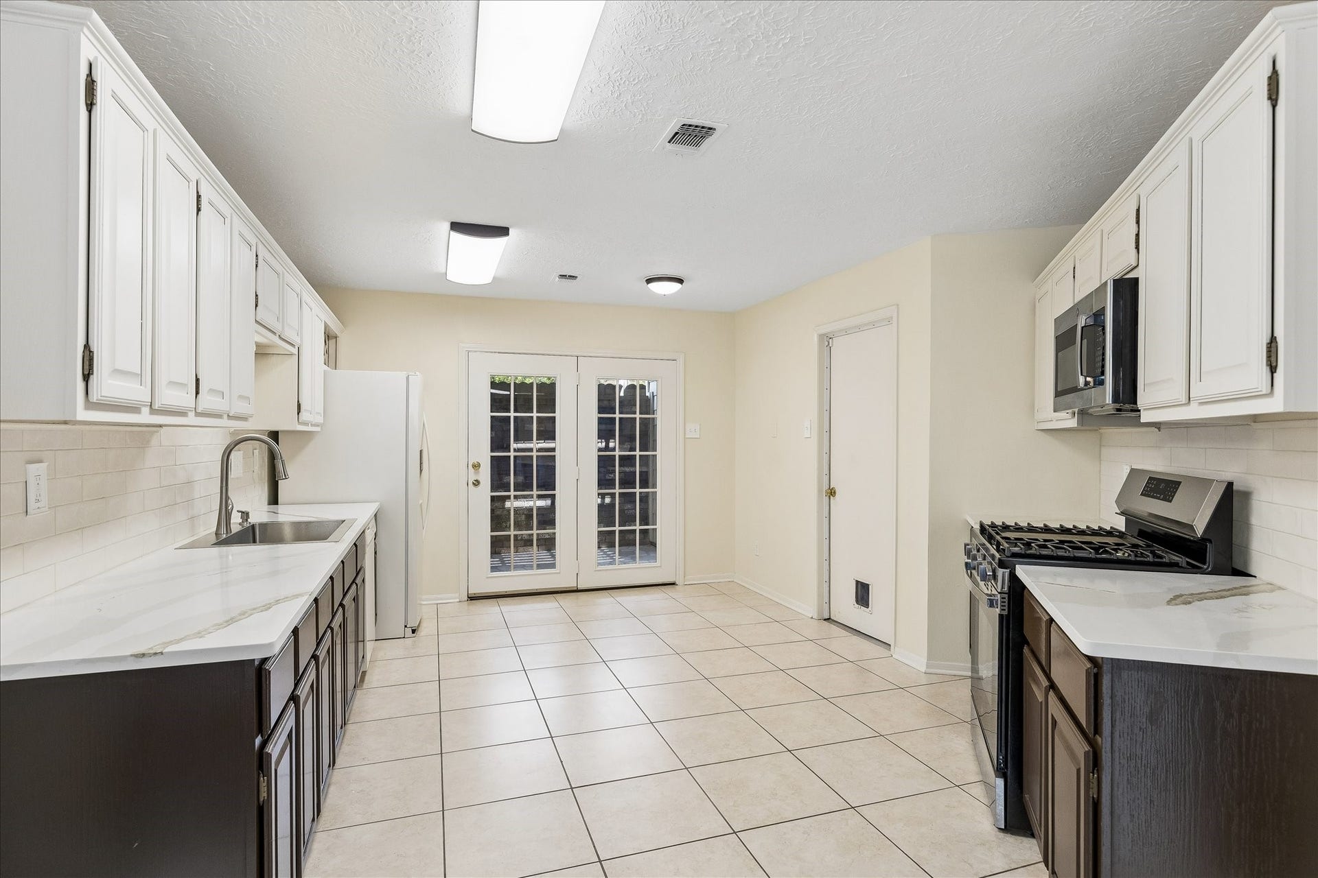 3806 Crystal Falls Drive, Missouri City, TX 77459 French doors connect the kitchen to a private atrium, adding charm and natural light.