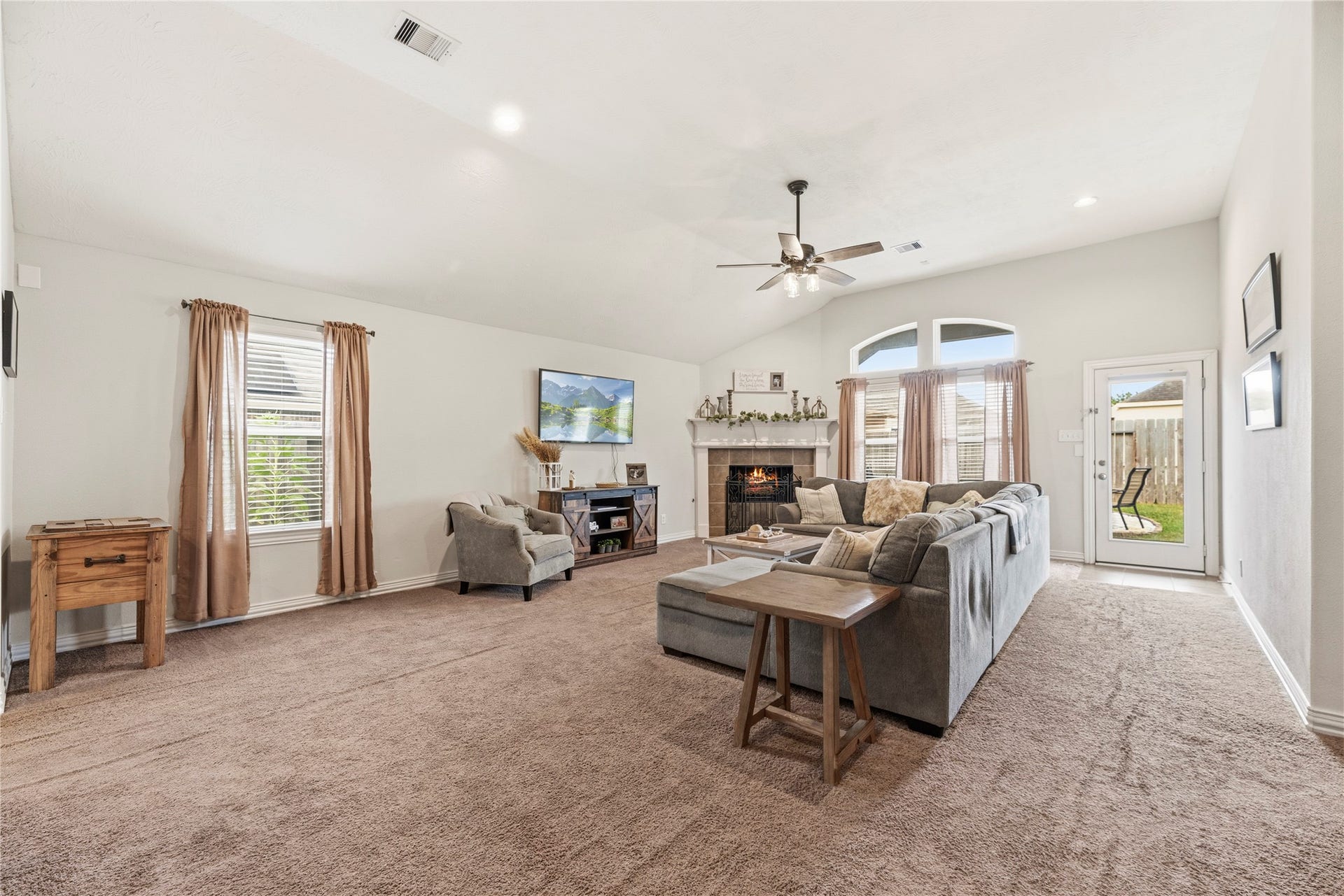 16014 Mark Crest Drive, Hockley, TX 77447 Spacious family room offers plush carpet, ceiling fan and a corner fireplace.