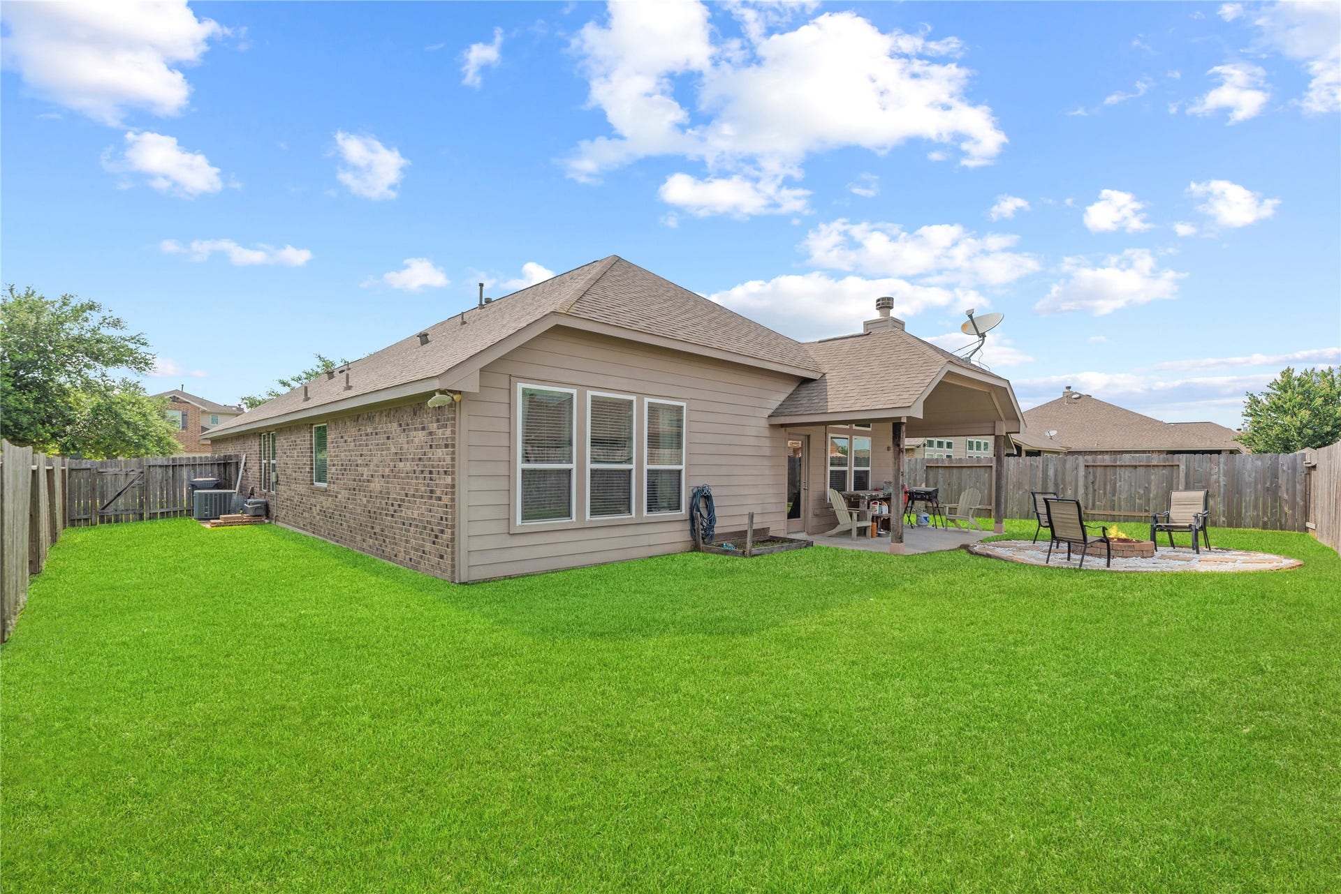 16014 Mark Crest Drive, Hockley, TX 77447 Private backyard with a covered patio and fire pit area.