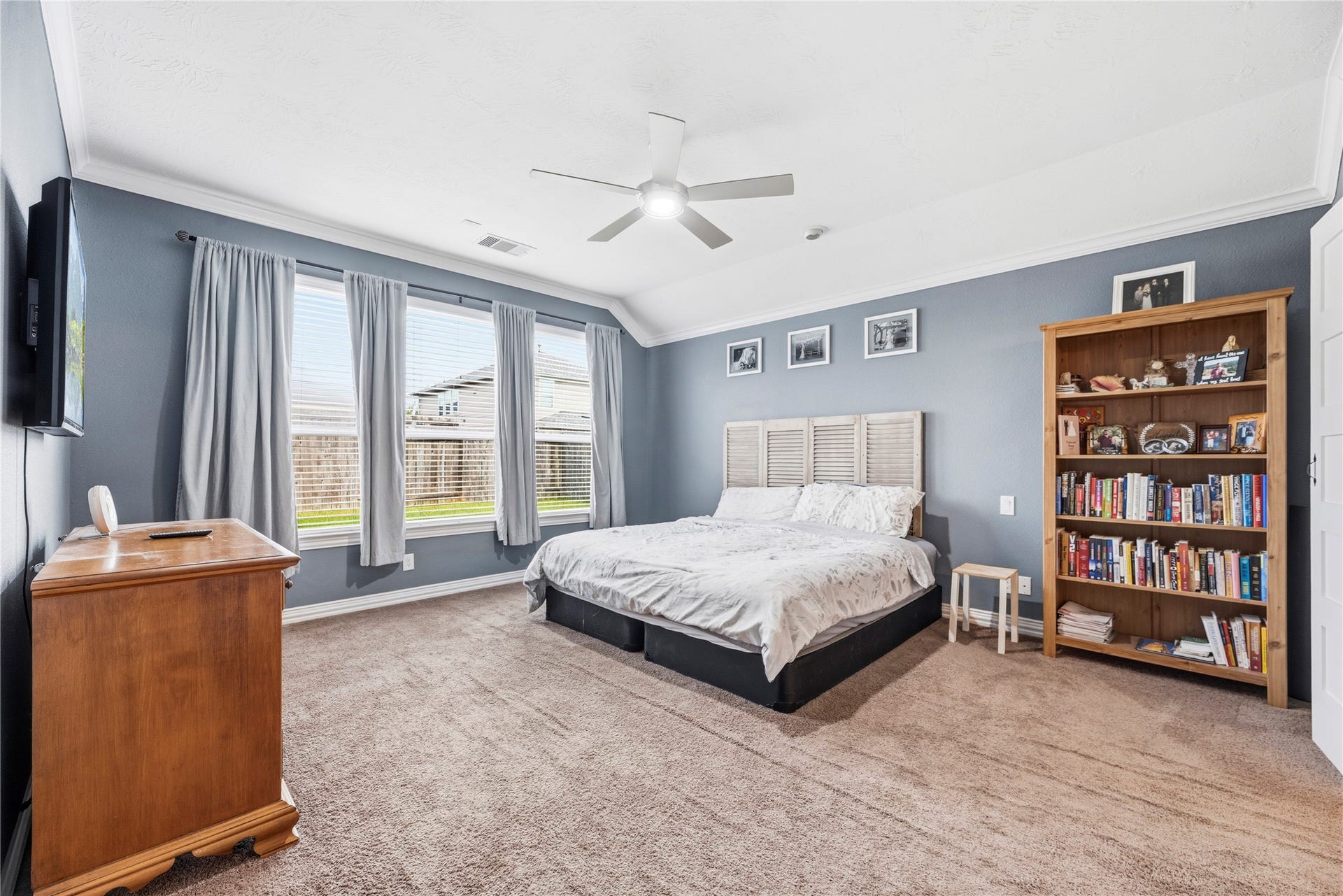16014 Mark Crest Drive, Hockley, TX 77447 Large primary retreat boasts a high ceiling, ceiling fan, crown molding, en-suite bathroom and great backyard views.