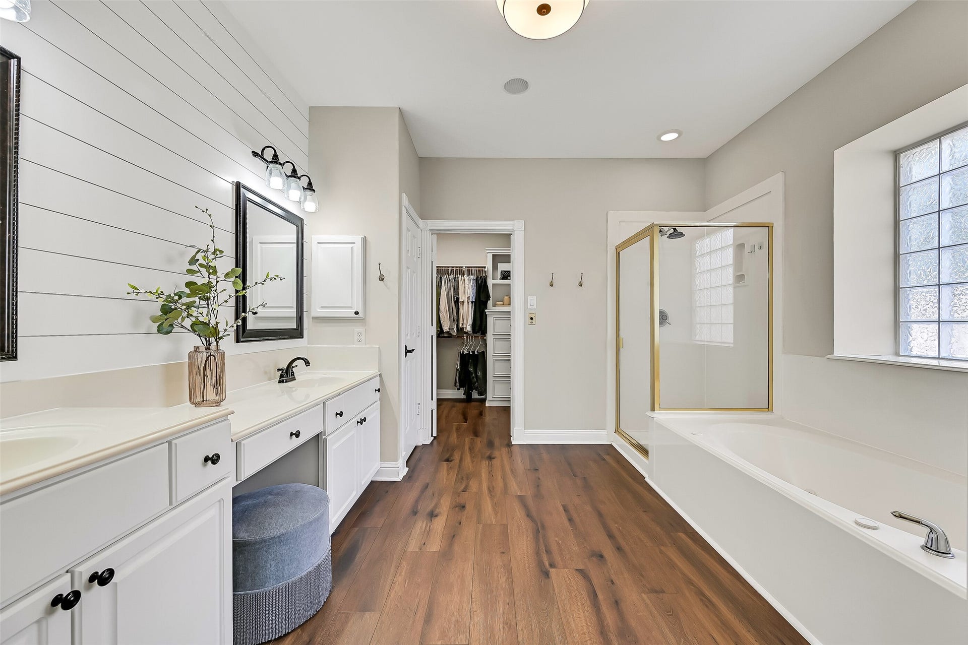2505 Sarasota Drive, Friendswood, TX 77546 The spacious primary bath offers an extended dual-sink vanity with dedicated seated makeup space, abundant cabinetry & a shiplap accent wall. LVP flooring continues into the bath, with the oversized walk-in closet conveniently located just beyond.