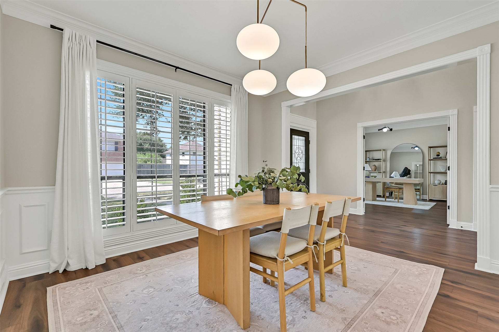 2505 Sarasota Drive, Friendswood, TX 77546 Another view of the formal dining room highlights its generous proportions and easy connection to the foyer. Detailed molding, plantation shutters, a contemporary chandelier & warm luxury vinyl plank flooring create an inviting space for gatherings.