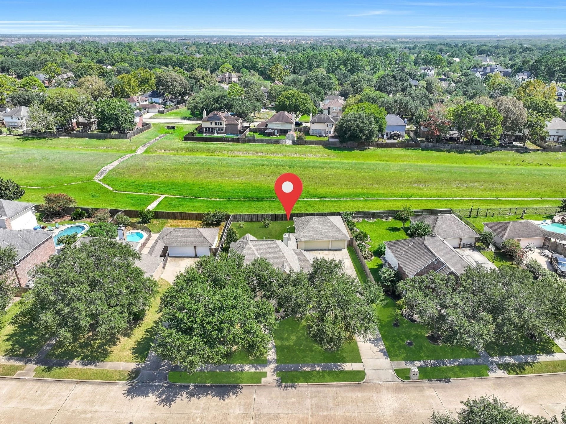 2505 Sarasota Drive, Friendswood, TX 77546 This aerial perspective captures the homes generous homesite, detached 3-car garage and expansive pool-sized backyard. Open space directly behind the property creates additional separation from neighboring homes and enhances the backyards sense of privacy.