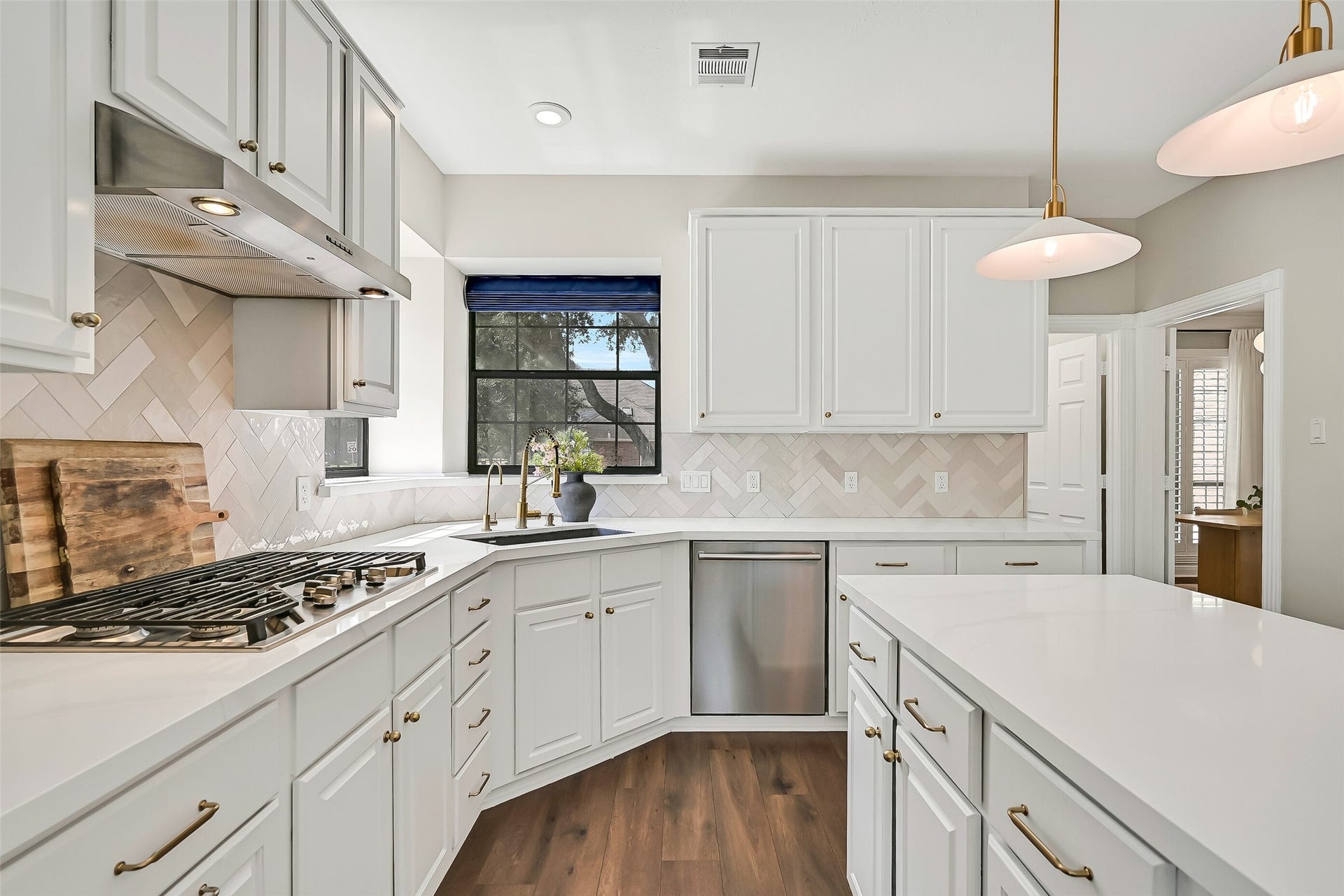 2505 Sarasota Drive, Friendswood, TX 77546 The spacious kitchen offers an abundance of cabinetry and workspace, including a large center island with seating. Quartzite counters, crisp white cabinetry, herringbone backsplash, gold-tone hardware & pendant lighting give the space a fresh, timeless look.