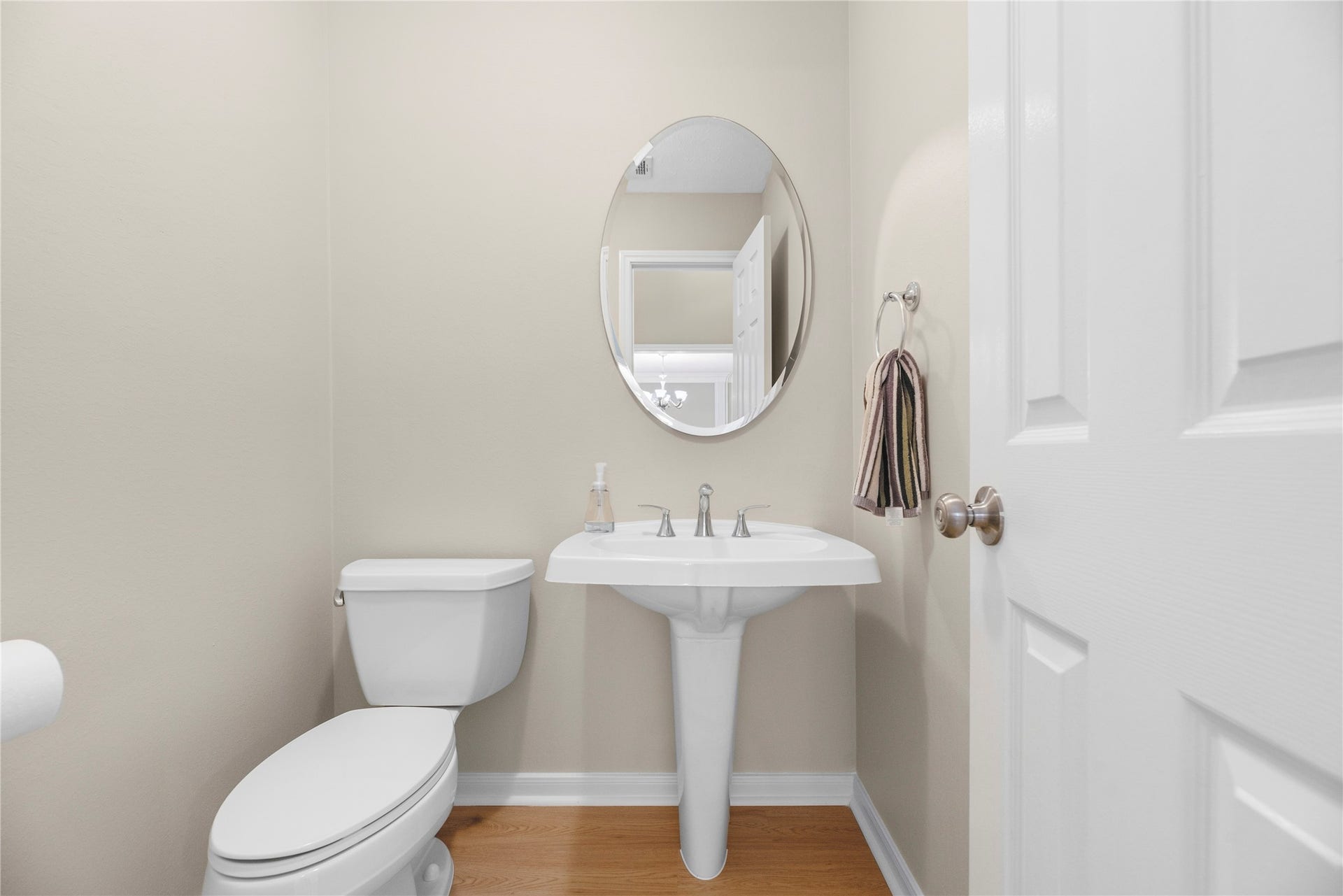 7426 Foxton Place Court, Houston, TX 77095 The 1st-floor powder bathroom is perfect for guests and everyday use, offering a classic pedestal sink and a beveled oval mirror for a polished finishing touch.