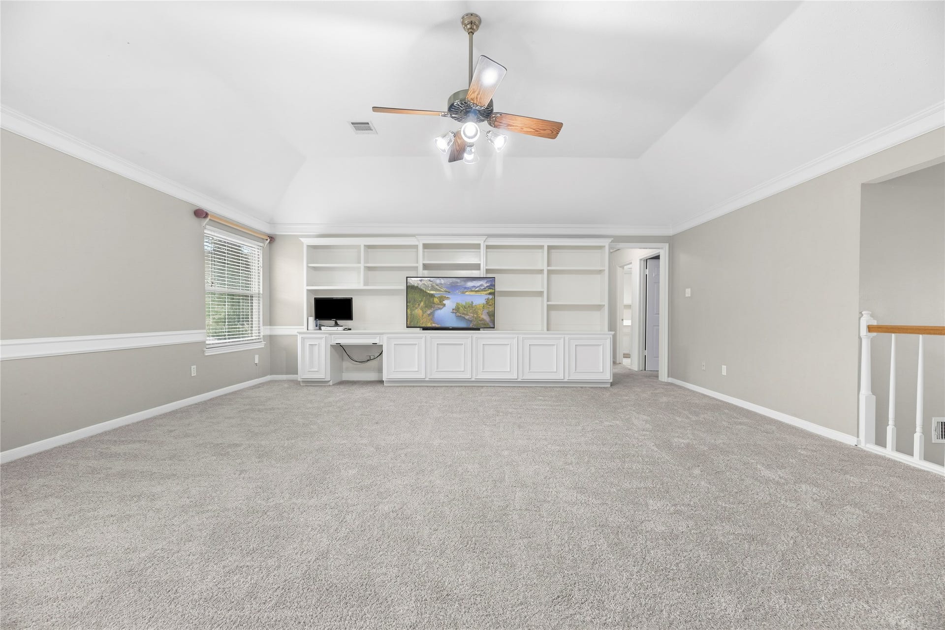 7426 Foxton Place Court, Houston, TX 77095 A full wall of custom built-ins offers open shelving, closed storage and a convenient desk, keeping games, electronics and everyday essentials organized without sacrificing style.