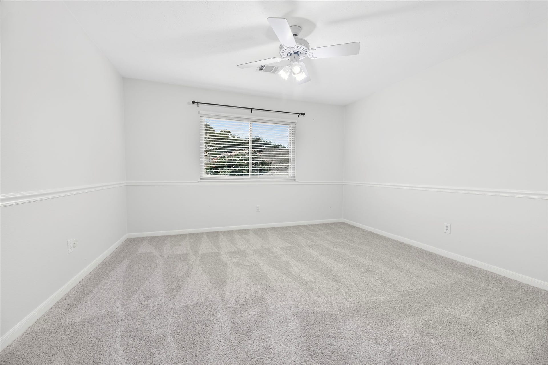 7426 Foxton Place Court, Houston, TX 77095 Your family and guests will rest comfortably in any of the three upstairs bedrooms. This roomy bedroom offers a large walk-in closet, updated carpet installed in July 2026, fresh paint, a ceiling fan and large windows that fill the space with natural light and peaceful treetop views.