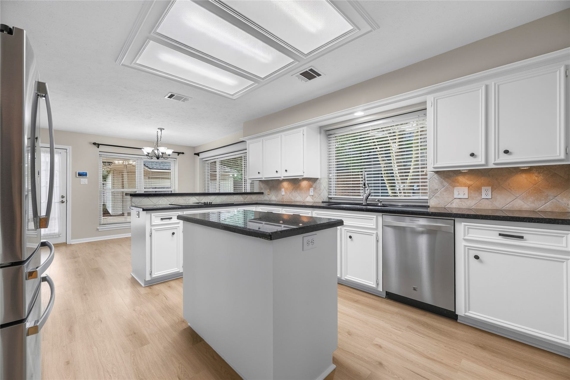 7426 Foxton Place Court, Houston, TX 77095 Show off your culinary skills in a kitchen designed to bring the joy into cooking. Find granite countertops, tumbled stone backsplash with under-cabinet lights, a center island plus extensive countertop space, built-in stainless-steel appliances, a sleek electric cooktop with an exhaust fan, bright overhead lighting plus a large window over the sink.