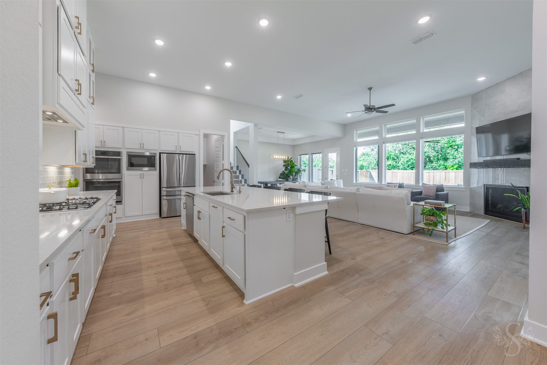 The open-concept kitchen and family room create an expansive setting for everyday living and entertaining. A wall of windows fills the space with natural light and draws attention to the homes beautiful interior finishes.