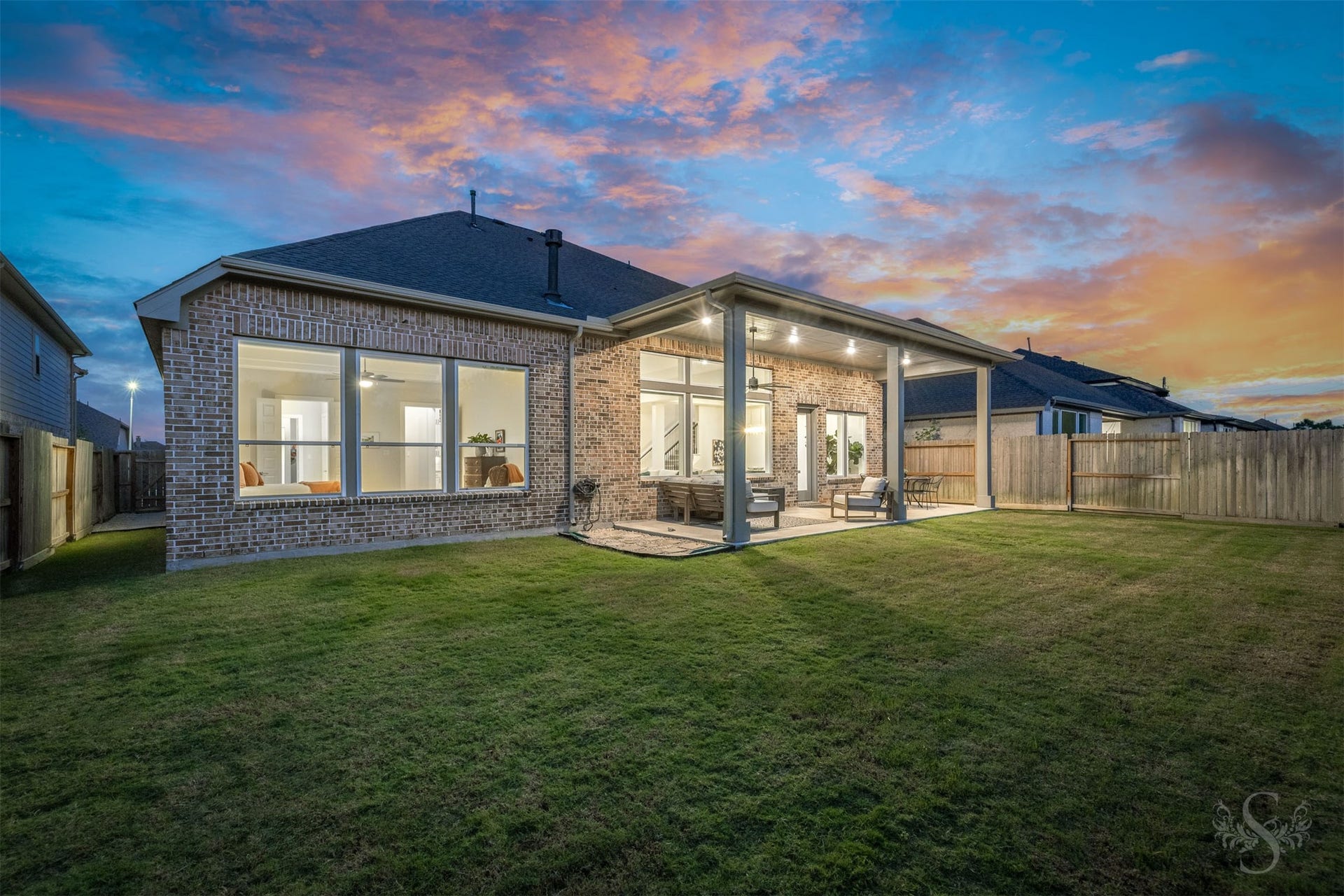 The extended covered patio creates a beautiful outdoor living space with plenty of room for relaxing and entertaining. Beyond the patio, the spacious fenced backyard offers endless possibilities for outdoor enjoyment.