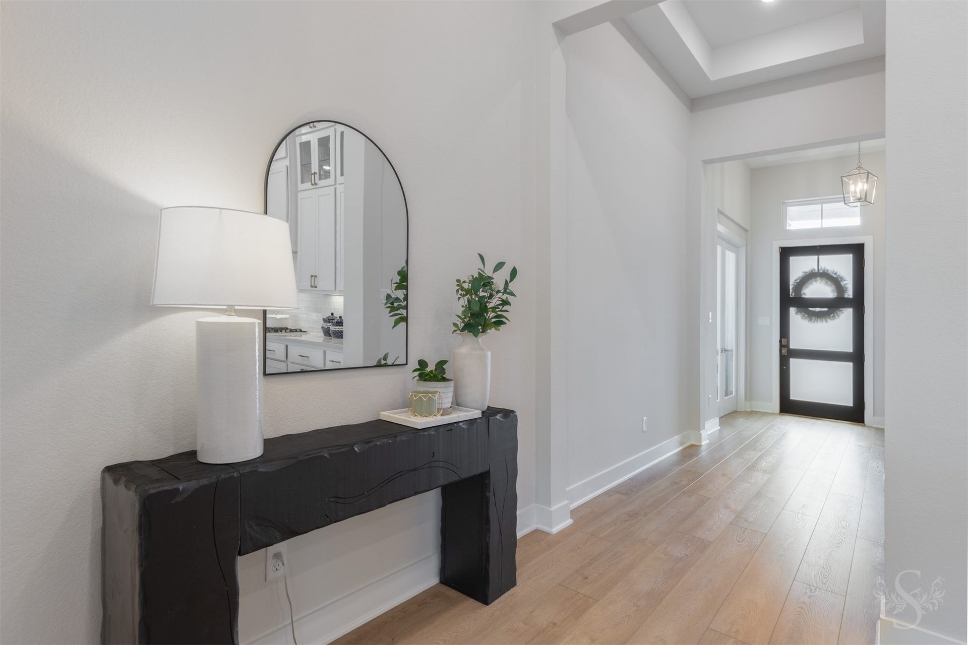 The impressive entry sets the tone with gorgeous vinyl plank flooring, a sleek modern front door and striking tray ceiling details. Contemporary lighting adds the perfect touch to this beautifully designed space.