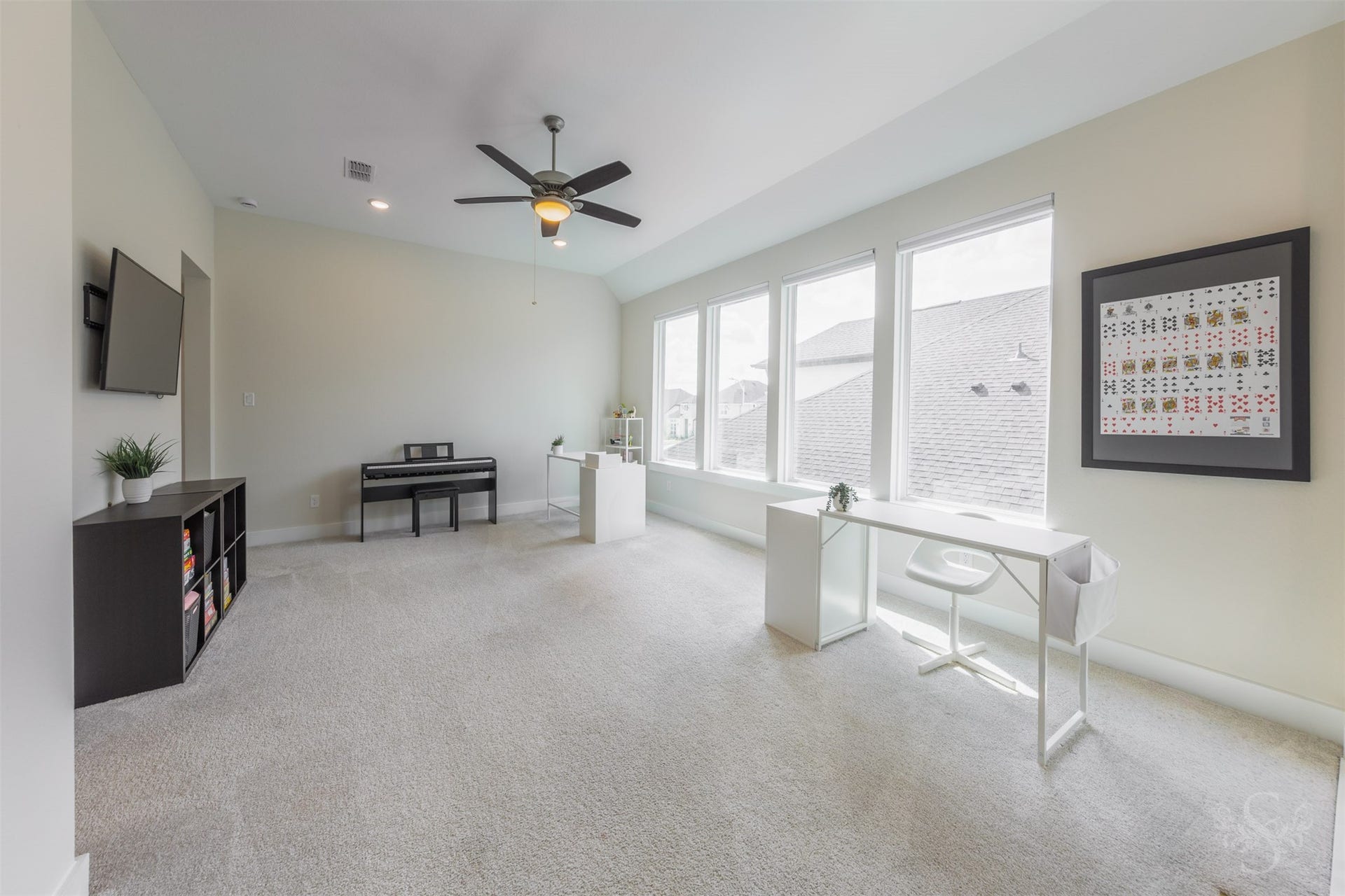 Impressive upstairs game room is enhanced by a dramatic vaulted ceiling and an expansive wall of windows. This light-filled retreat offers an exceptional amount of space for games, hobbies and memorable family fun.