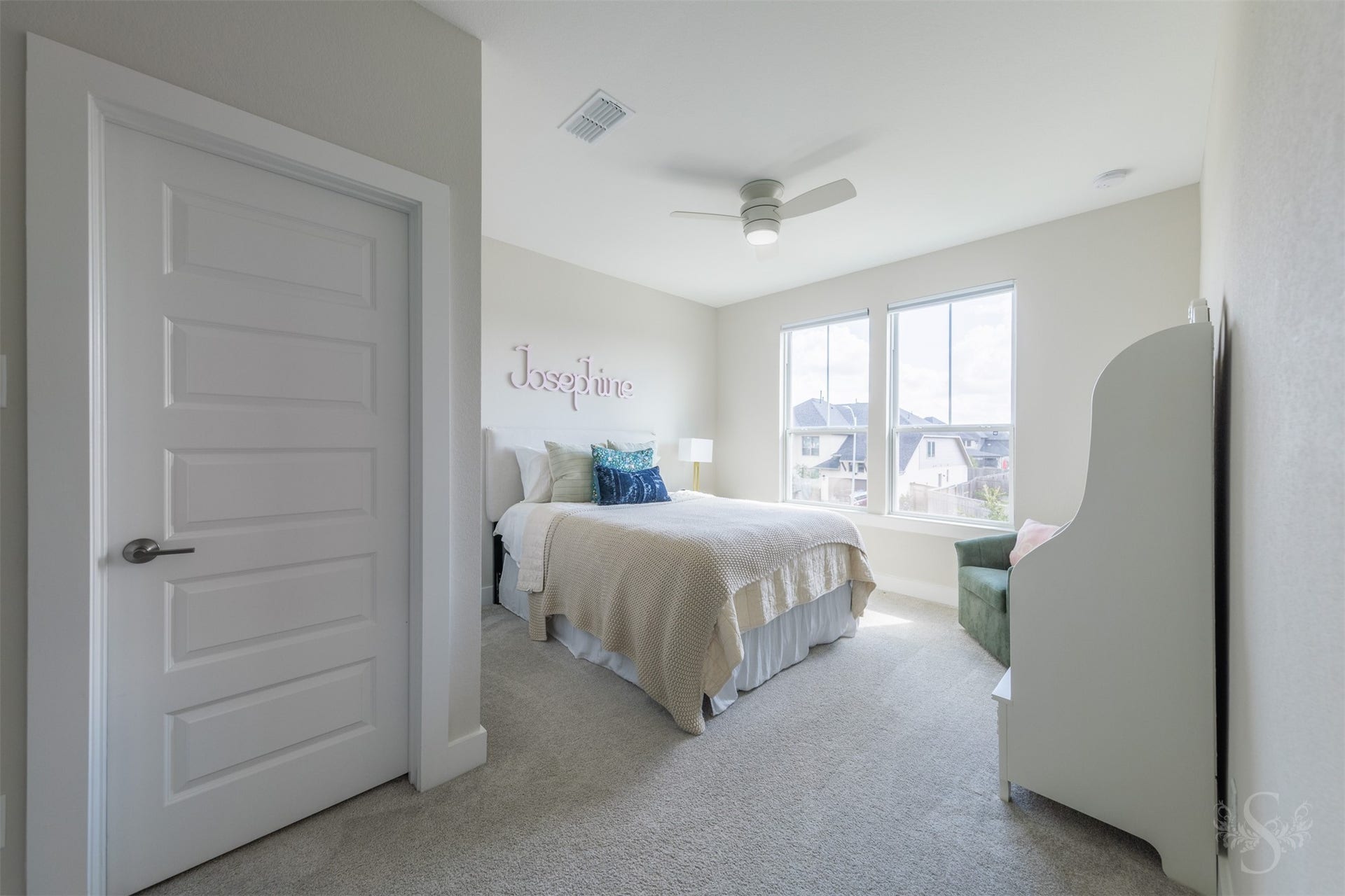 Another spacious upstairs bedroom is beautifully illuminated by a pair of large windows and offers room for a reading or study area. Neutral tones provide a sophisticated backdrop for any style.