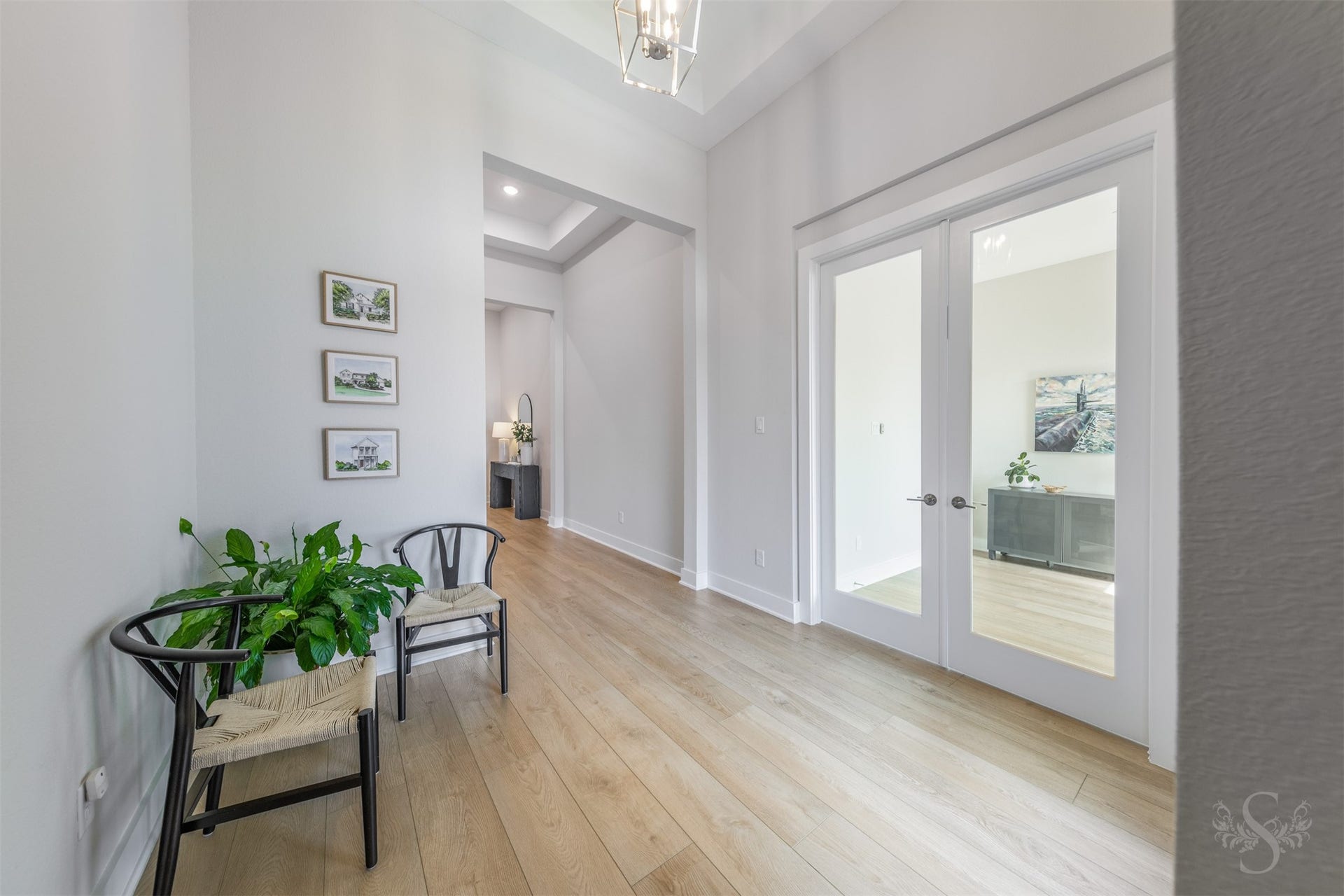 The impressive entry is beautifully appointed with striking flooring, graceful tray ceiling details and a statement light fixture. Glass French doors introduce the private study, offering an elegant first glimpse into the homes exceptional interior.