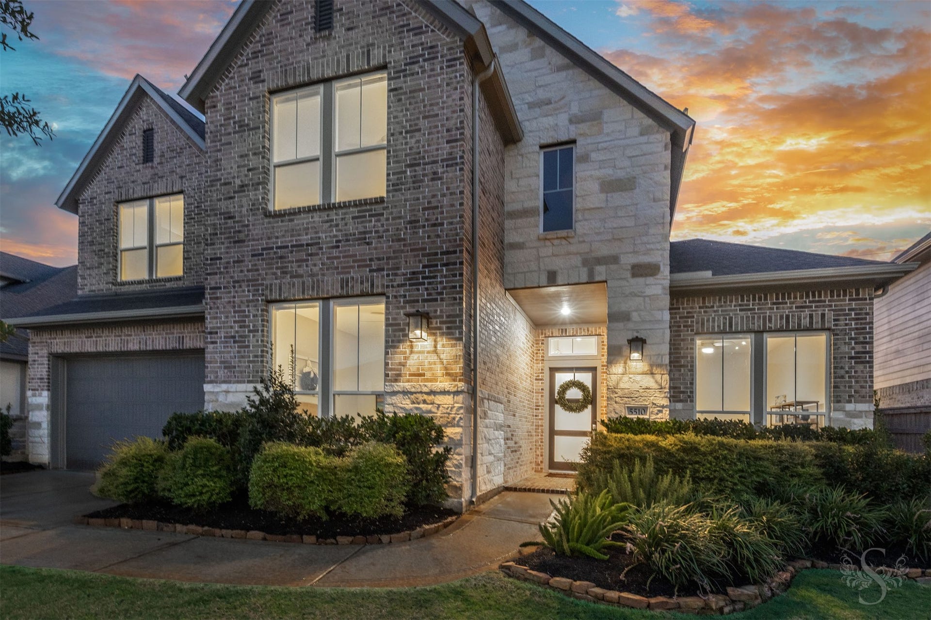Striking brick-and-stone architecture gives this 2024 home a sophisticated modern presence in Cross Creek Ranch. Dramatic rooflines, warm exterior lighting and beautifully maintained landscaping create unforgettable curb appeal.