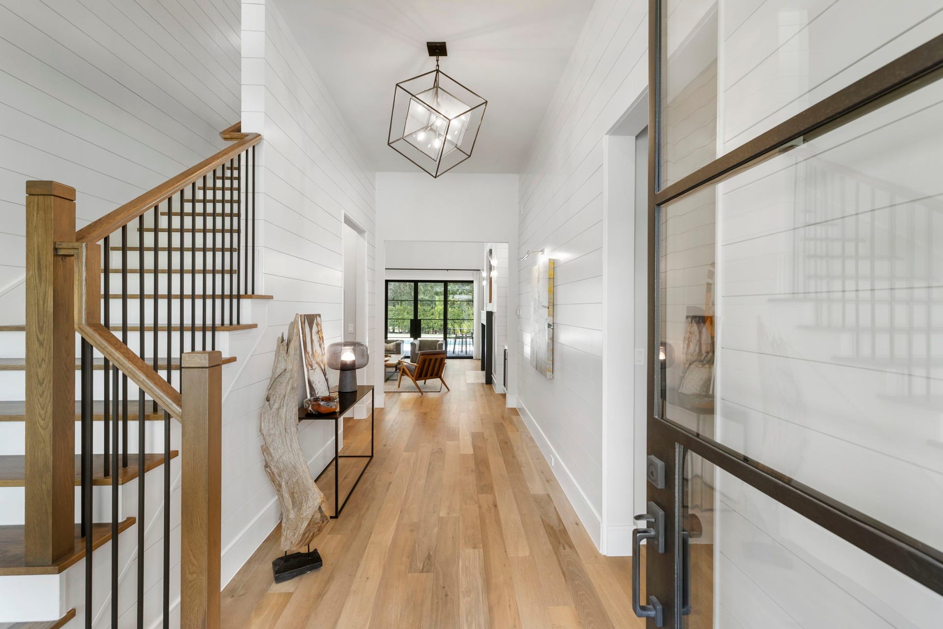 Inside, the formal entry is light and bright, showcasing shiplap walls that beautifully complement engineered white oak flooring throughout.