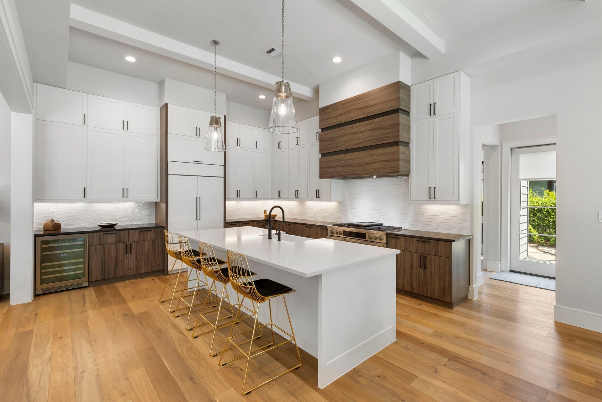 Warm and inviting, the kitchen centers on a generous island, seating for four and a well thought serving area with added wine fridge.