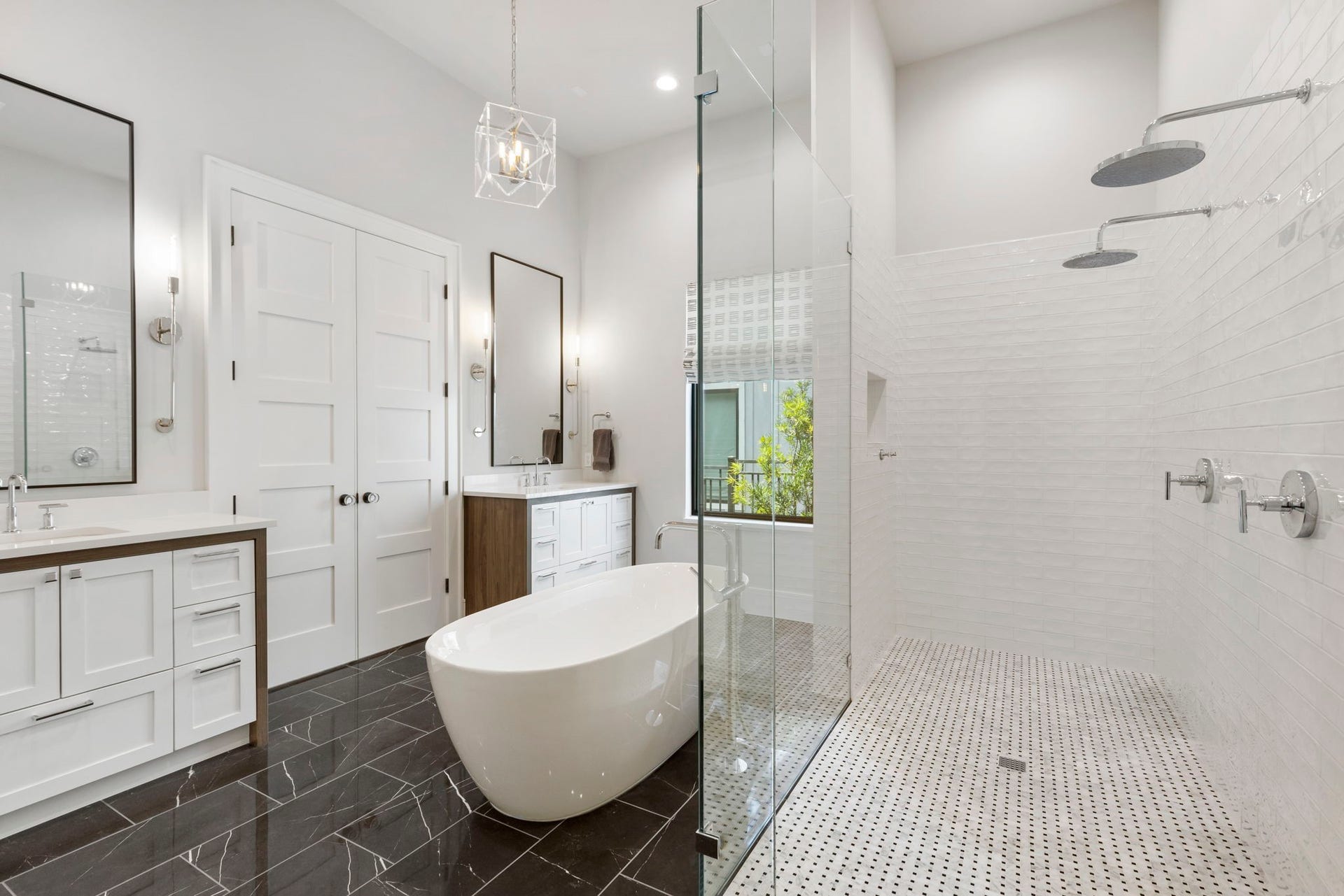 Separate his-and-her vanities feature white quartz countertops with eye-catching white and walnut toned cabinetry completes the space.