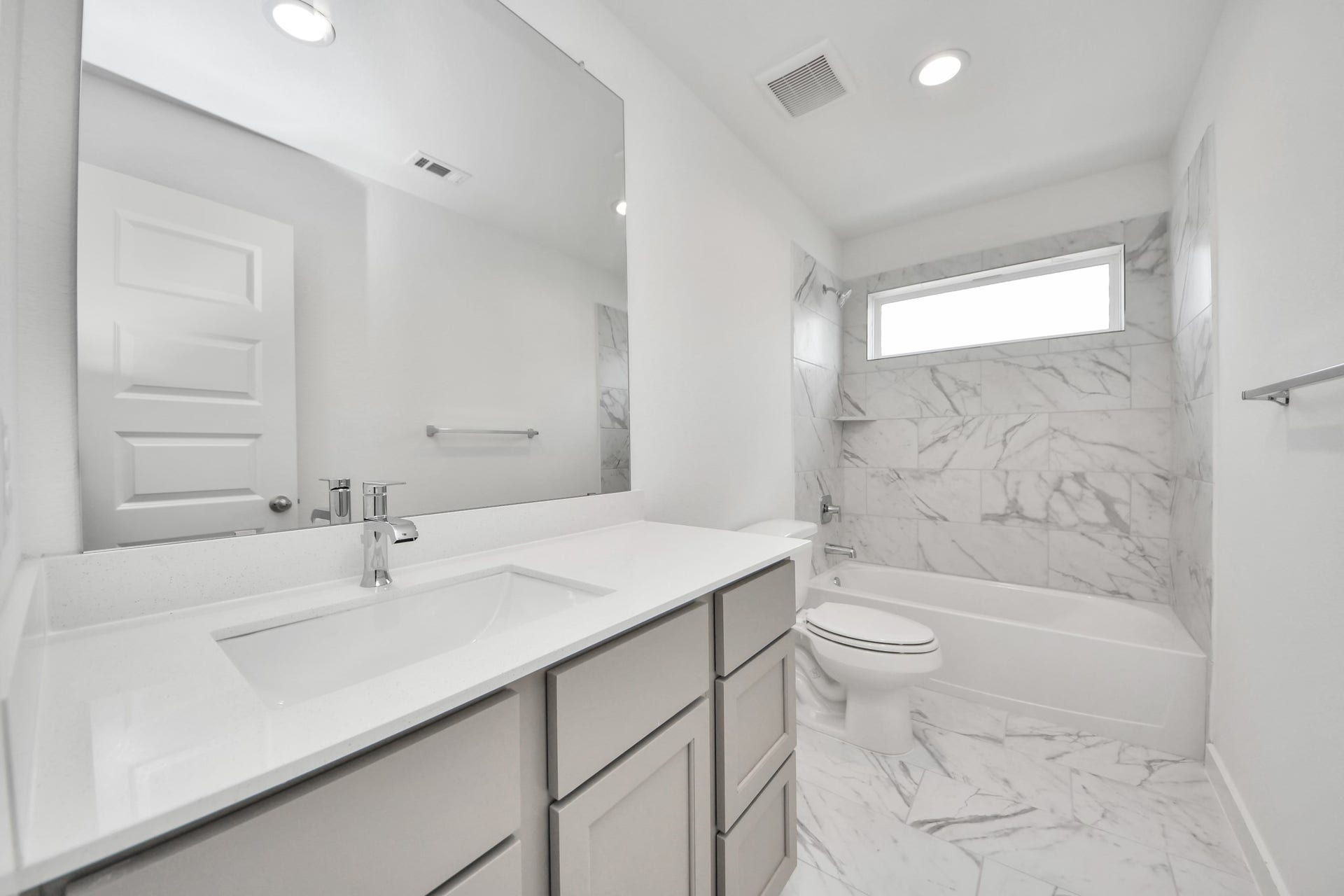 19046 Cape Capasso Drive, Hockley, TX 77447 Secondary bath features tile flooring, bath/shower combo with tile surround, light stained wood cabinets, beautiful light countertop. Sample photo of completed home with similar floor plan. Actual colors and selections may vary.