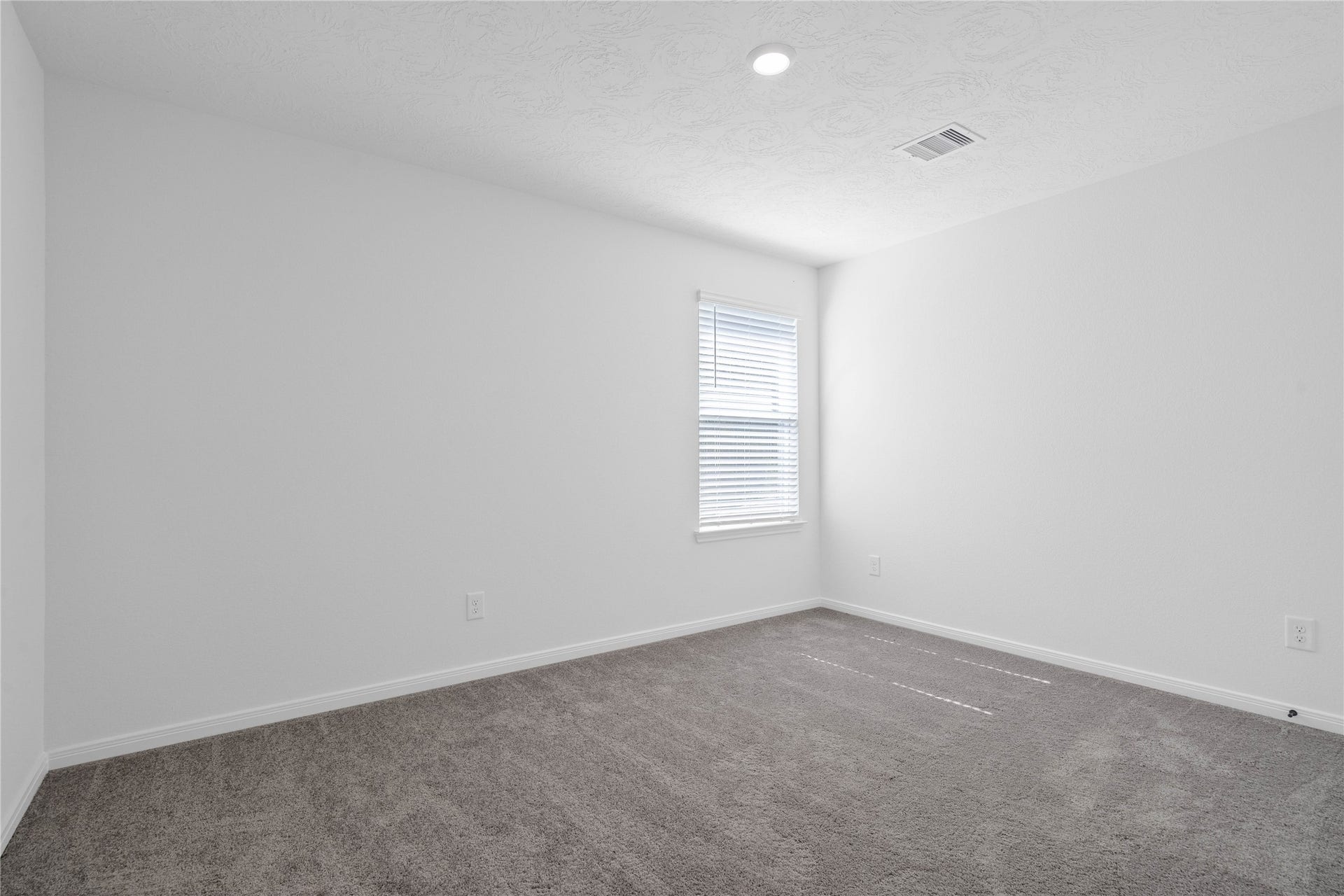 10160 Maple Cove Lane, Willis, TX 77378 This secondary bedroom offers comfort and style with plush carpeting, neutral paint tones, recessed lighting, a large window, and a generously sized closet.