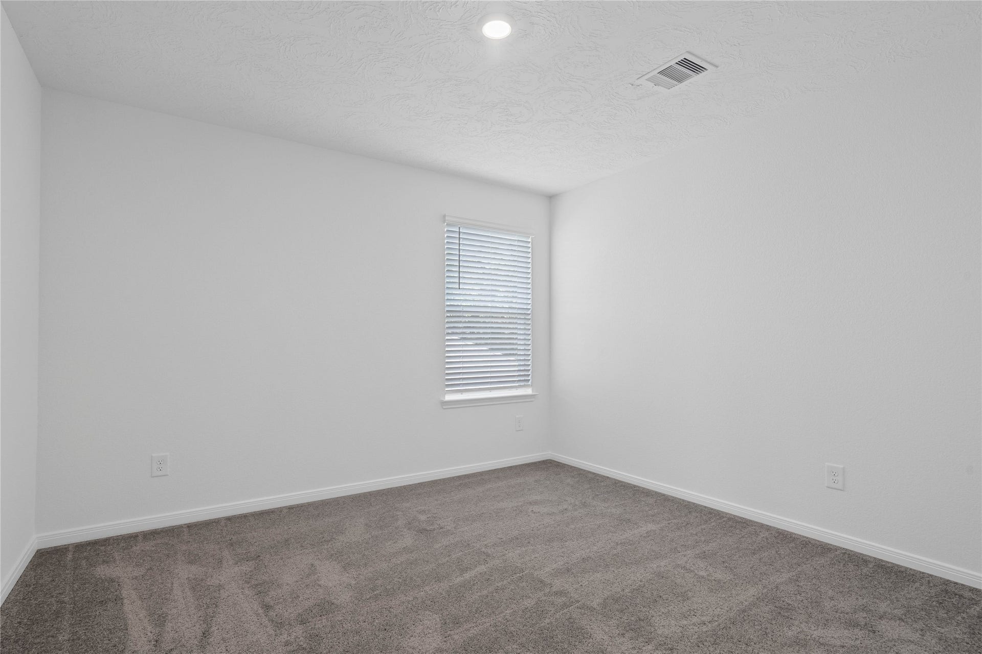 10160 Maple Cove Lane, Willis, TX 77378 This secondary bedroom offers comfort and style with plush carpeting, neutral paint tones, recessed lighting, a large window, and a generously sized closet.