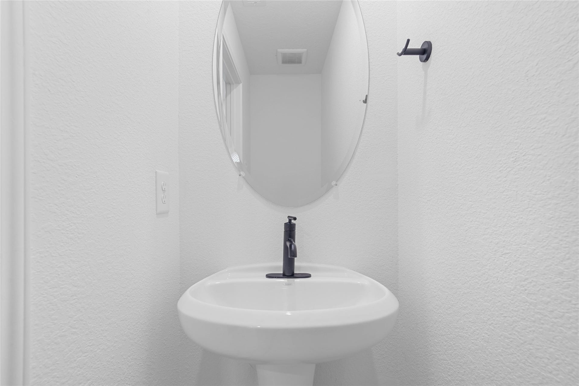 10160 Maple Cove Lane, Willis, TX 77378 The powder room on the first floor includes a pedestal sink, mirror, and toilet to conveniently meet your needs.