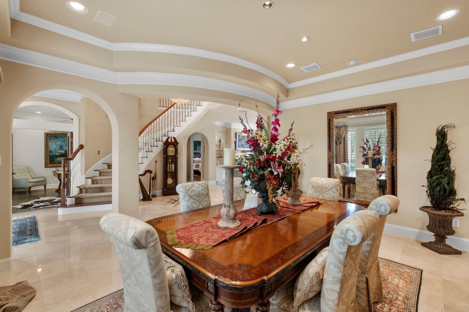 7 Silverloch Court, Sugar Land, TX 77479 Elegant dining area seamlessly connected to a grand staircase and cozy seating nook through graceful archways.