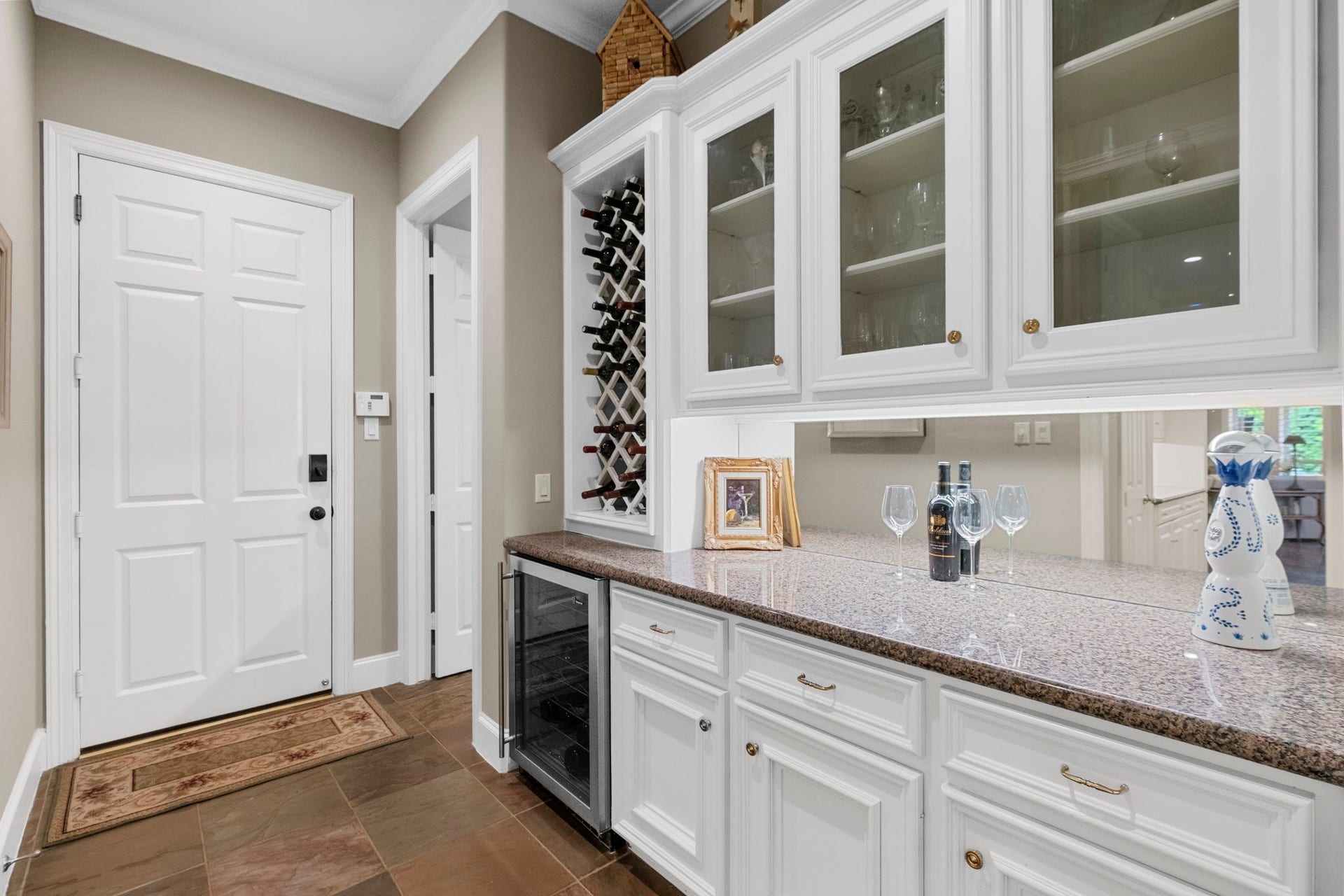 7 Silverloch Court, Sugar Land, TX 77479 Elegant butler's pantry featuring glass-front cabinets, a built-in wine rack, and a sleek countertop perfect for hosting family and friends.