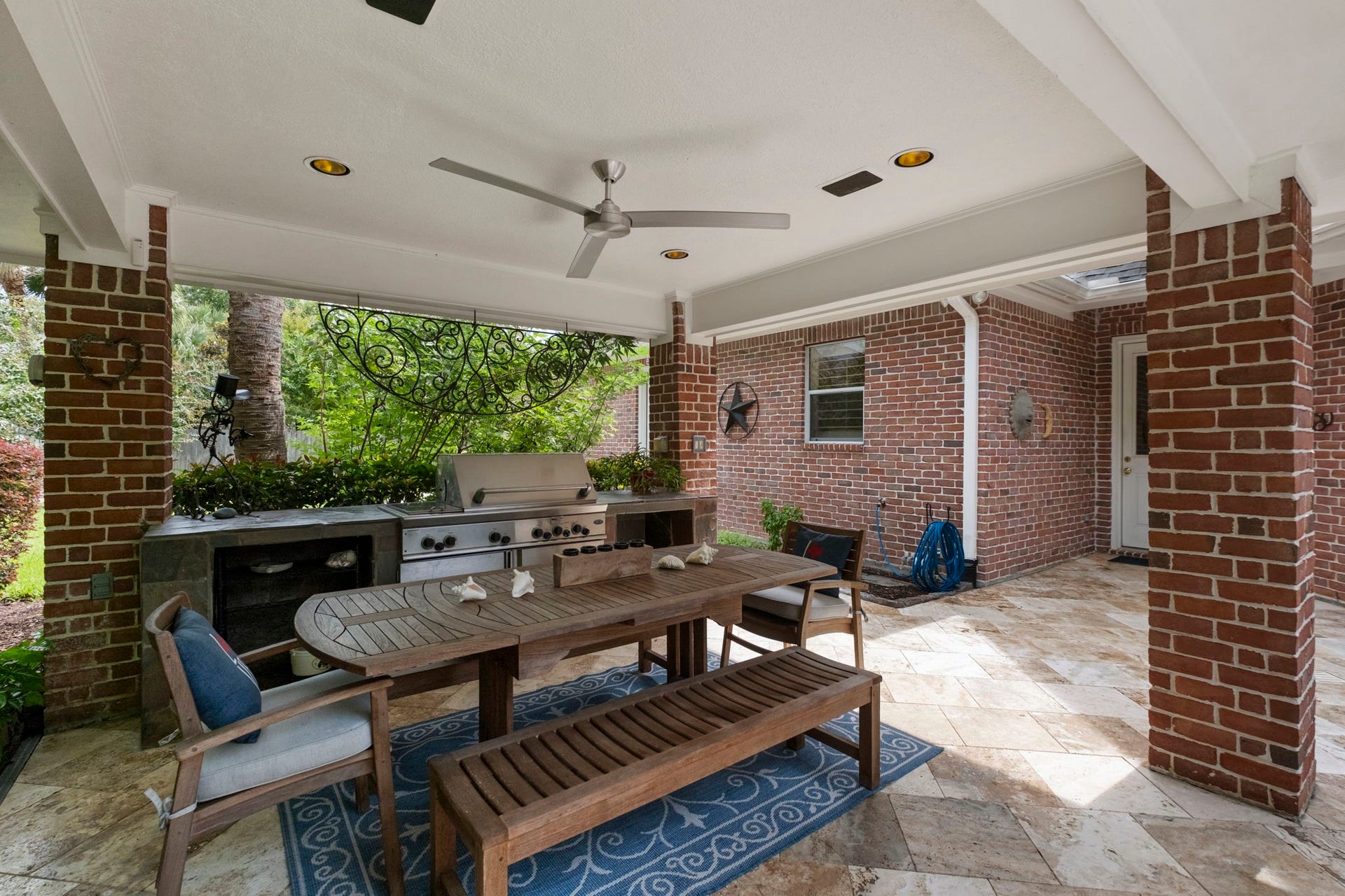 7 Silverloch Court, Sugar Land, TX 77479 Charming outdoor patio featuring a stylish brick design, complete with a built-in grill and spacious dining area, perfect for entertaining.