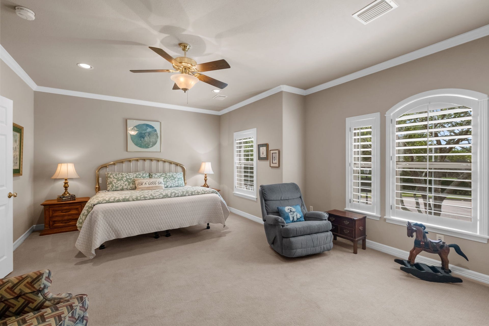 7 Silverloch Court, Sugar Land, TX 77479 Spacious 2nd Primary Bedroom with soft, neutral tones features a cozy seating area, and large windows with plantation shutters for abundant natural light.