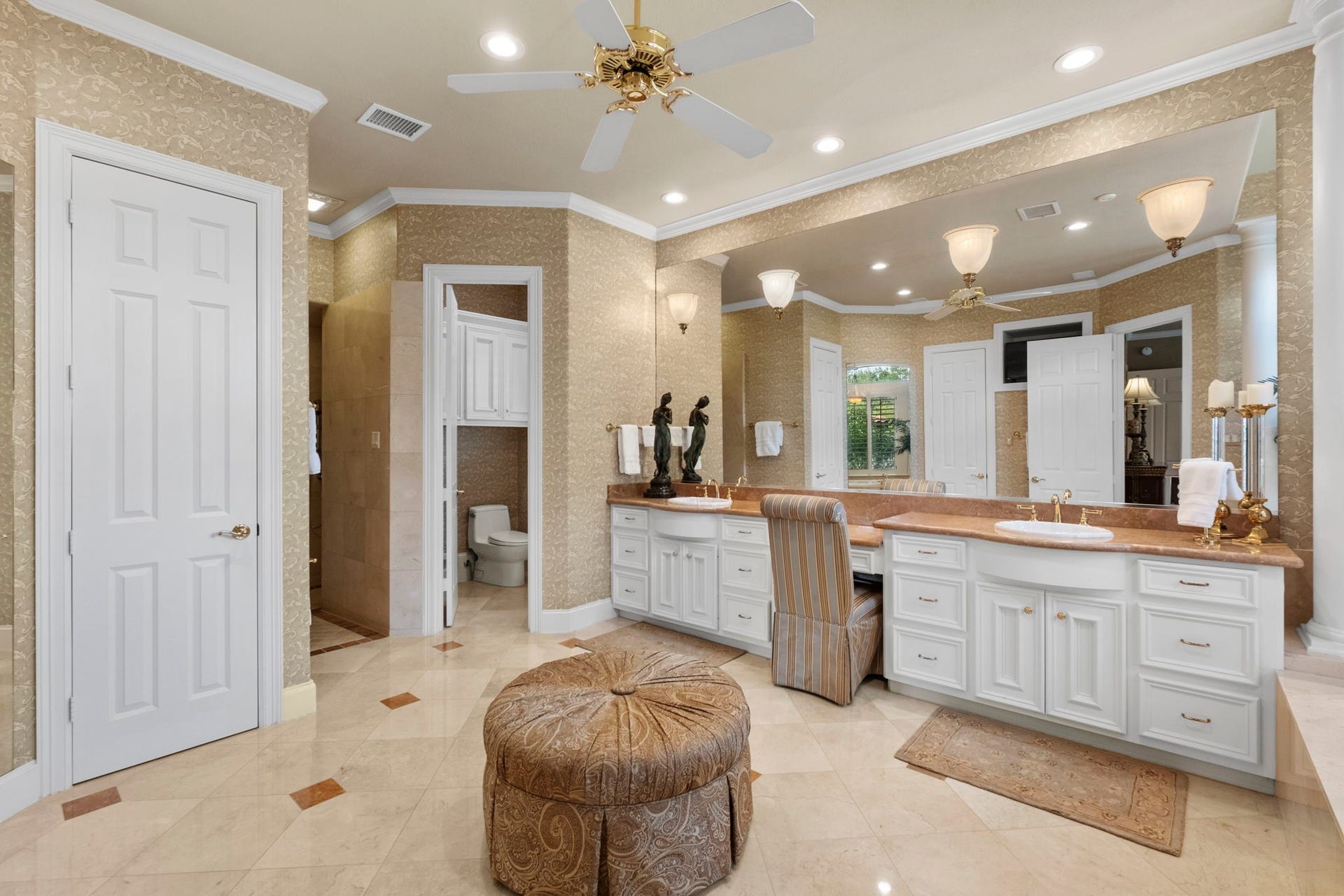 7 Silverloch Court, Sugar Land, TX 77479 Luxurious bathroom featuring dual vanities with elegant marble countertops, a spacious seating area, and warm ambient lighting.
