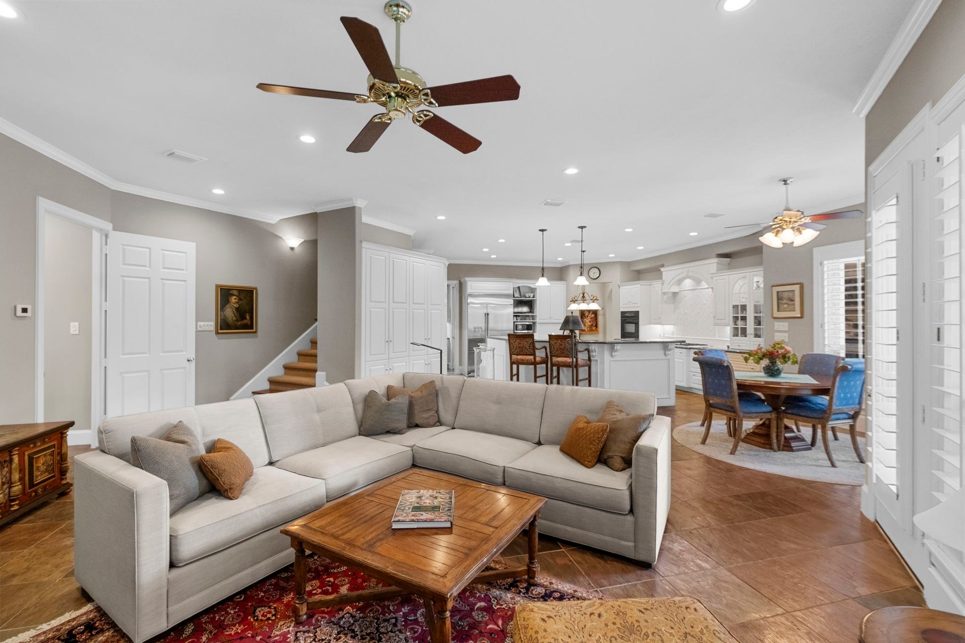 7 Silverloch Court, Sugar Land, TX 77479 Spacious open-concept living area features an elegant ceiling fan, and a seamless flow into the modern kitchen and dining space, perfect for entertaining.