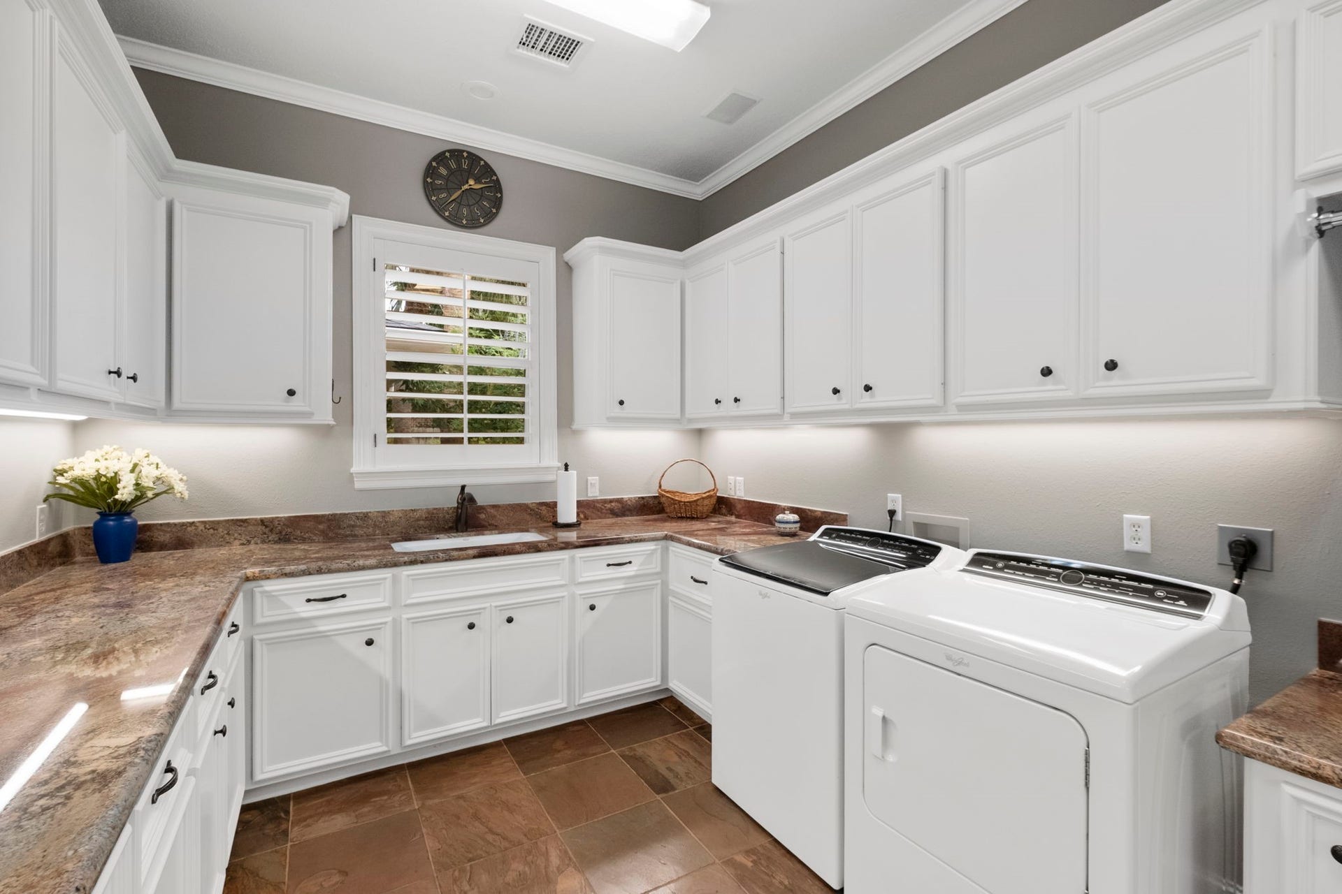 7 Silverloch Court, Sugar Land, TX 77479 Spacious laundry room featuring sleek white cabinetry, ample counter space, modern appliances, and a sink complemented by a window for natural light.