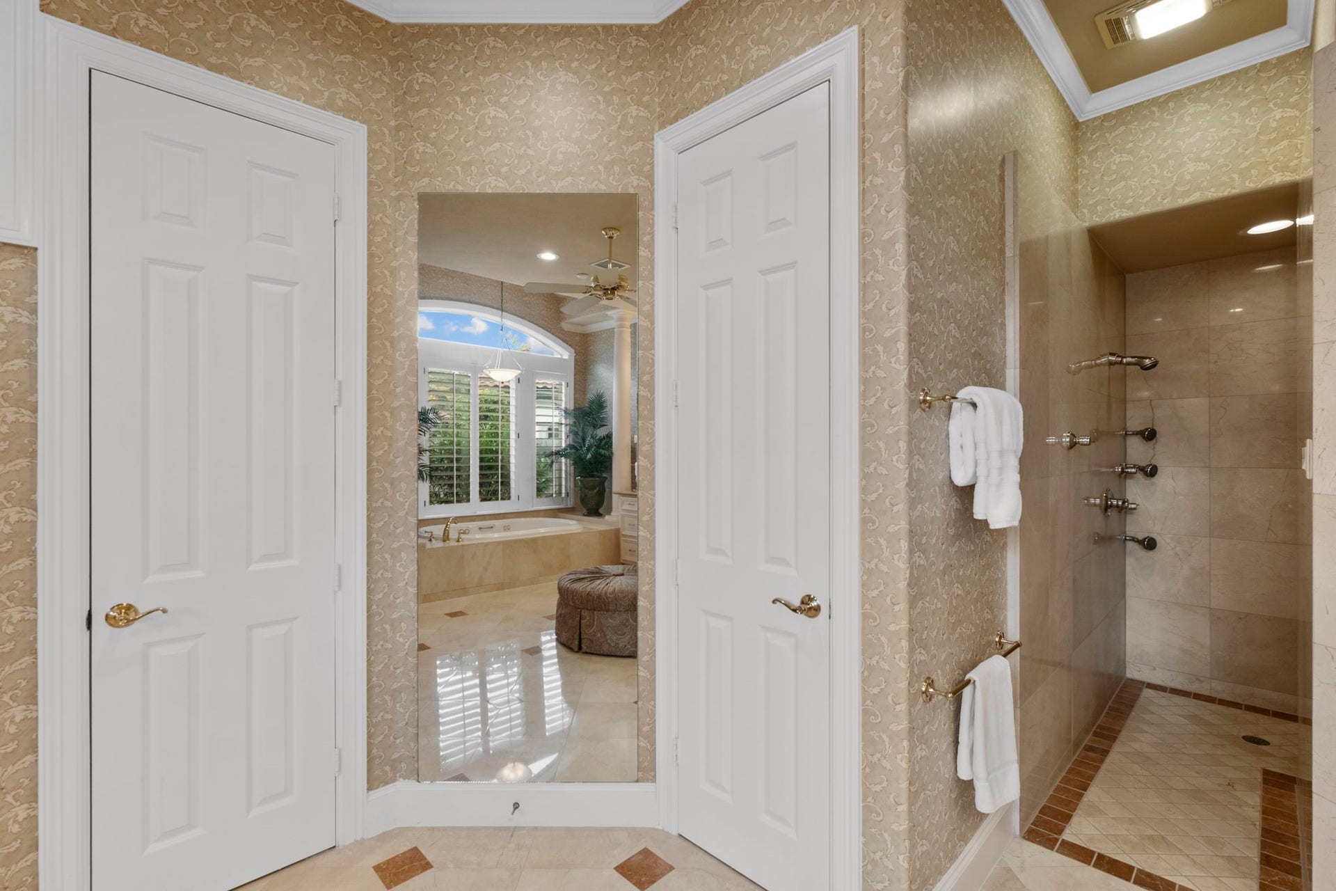 7 Silverloch Court, Sugar Land, TX 77479 Elegant bathroom featuring a spacious walk-in shower with multiple showerheads, luxurious tub with garden views, and sophisticated tile accents.