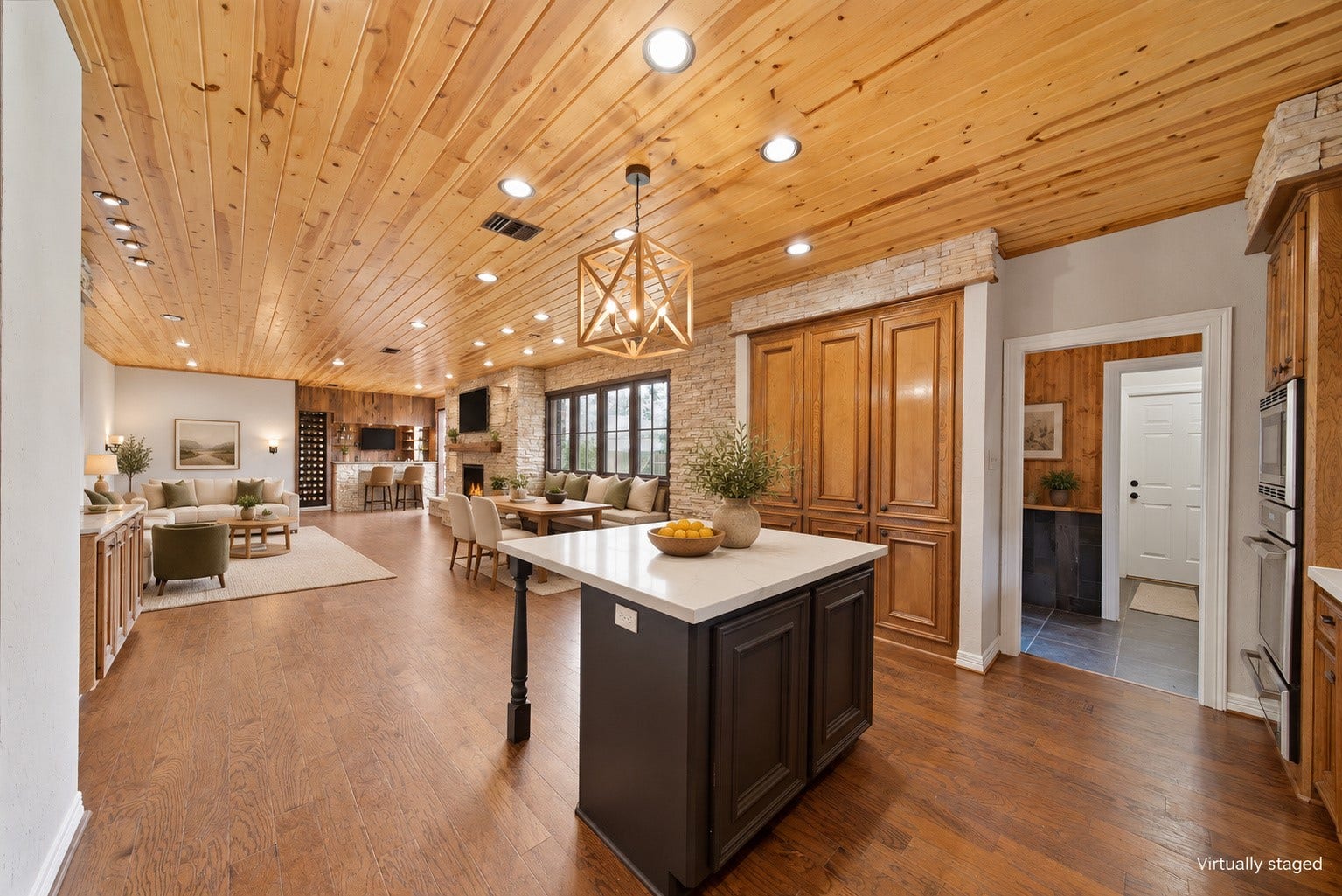 Virtually staged to show the flow of the living, dining, bar and kitchen.