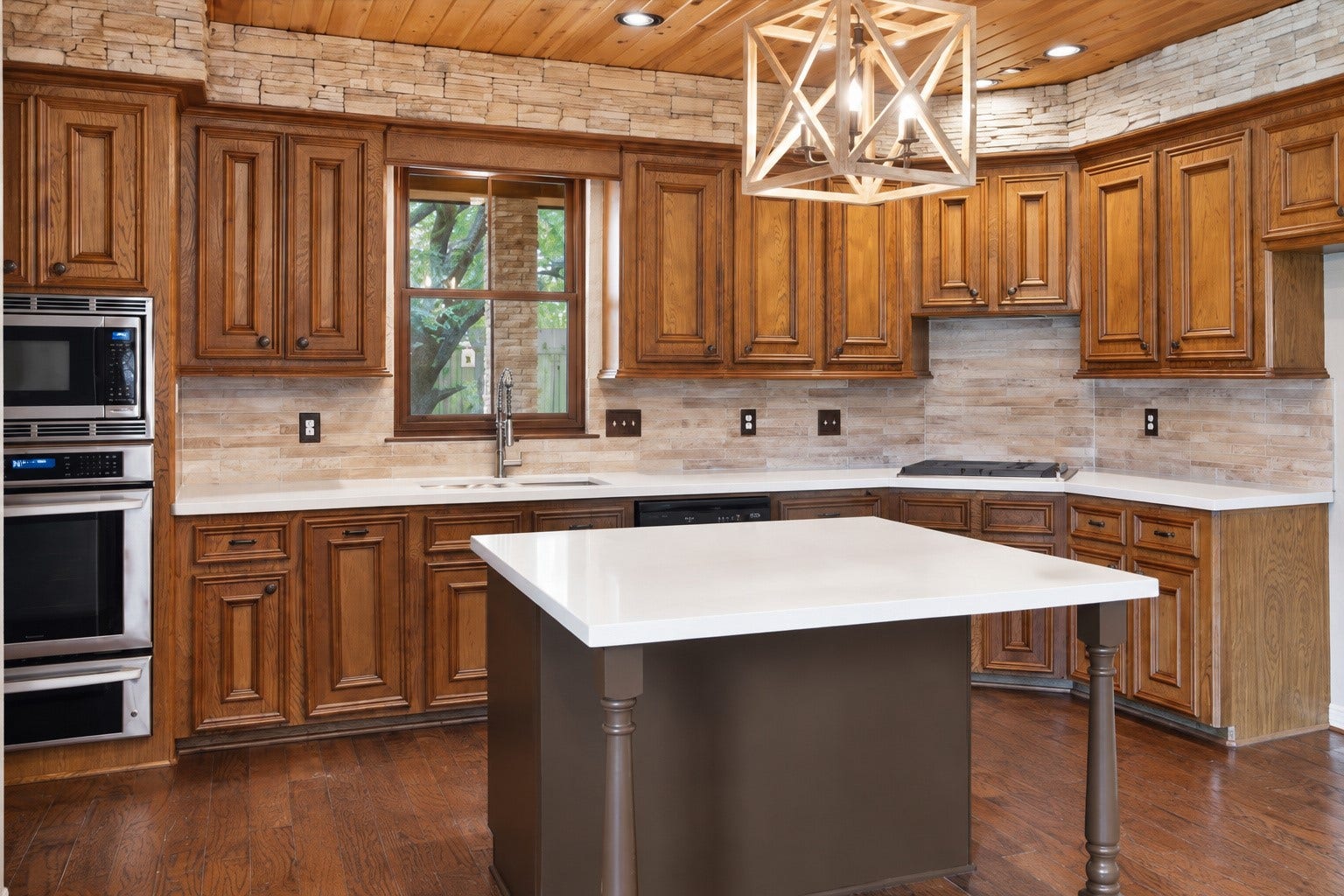 Renovated kitchen with quartz island and countertops, stunning backsplash and rich cabinets.