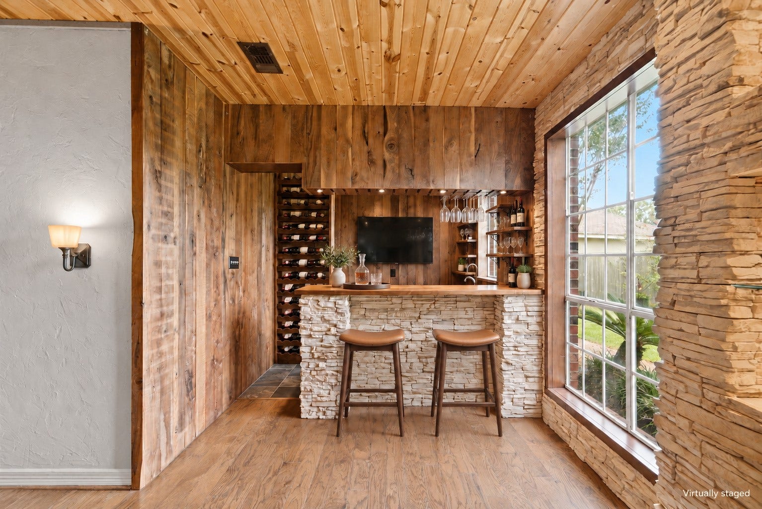 Virtually staged to show TV and wine storage. Bar includes outlet for TV.
