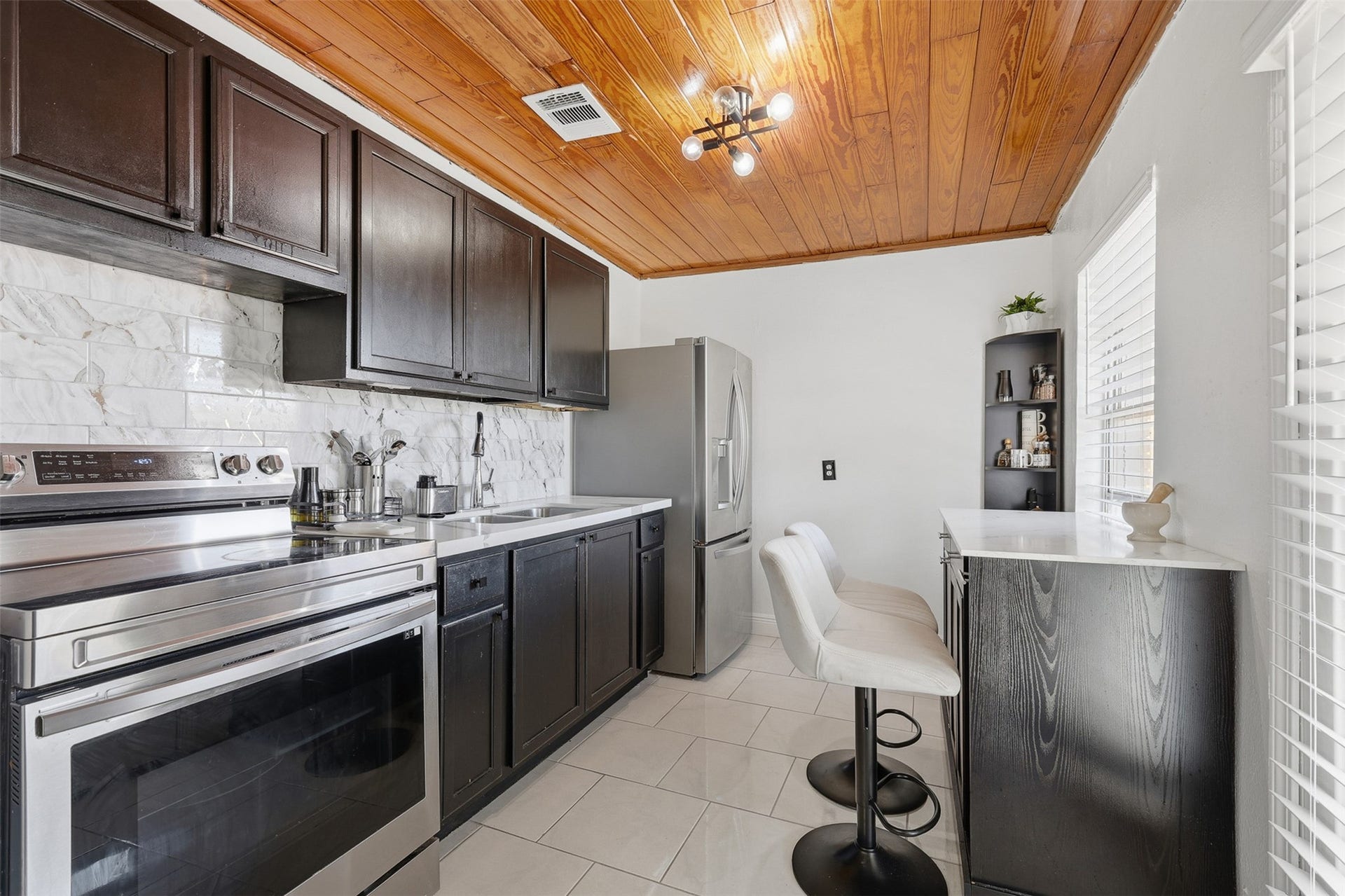 2205 Strawberry Road, Pasadena, TX 77502 Updated kitchen featuring modern backsplash, quartz countertops, and stylish finishes designed for both functionality and comfort.