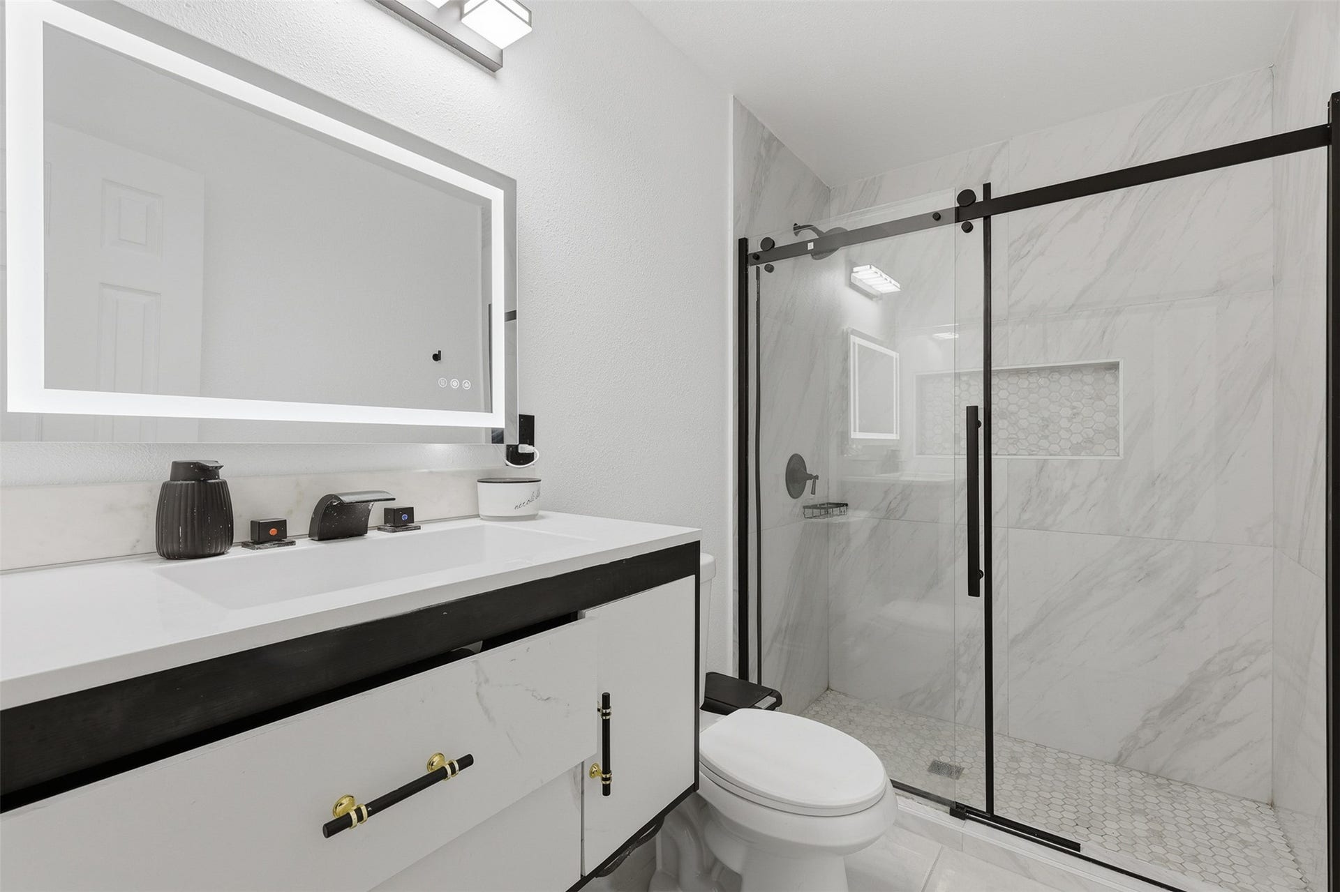 2205 Strawberry Road, Pasadena, TX 77502 Recently updated primary bathroom with spacious walk-in shower, illuminated mirror and modern fixtures.