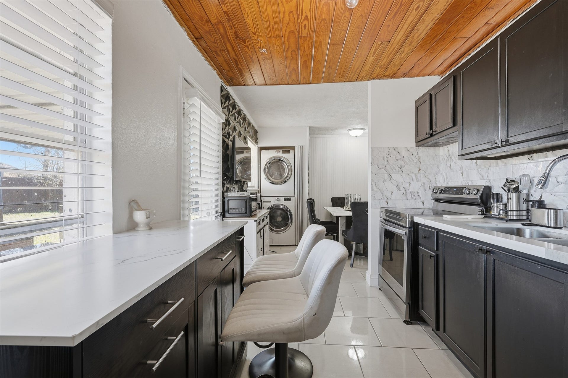 2205 Strawberry Road, Pasadena, TX 77502 Updated kitchen featuring modern backsplash, quartz countertops, and stylish finishes designed for both functionality and comfort.