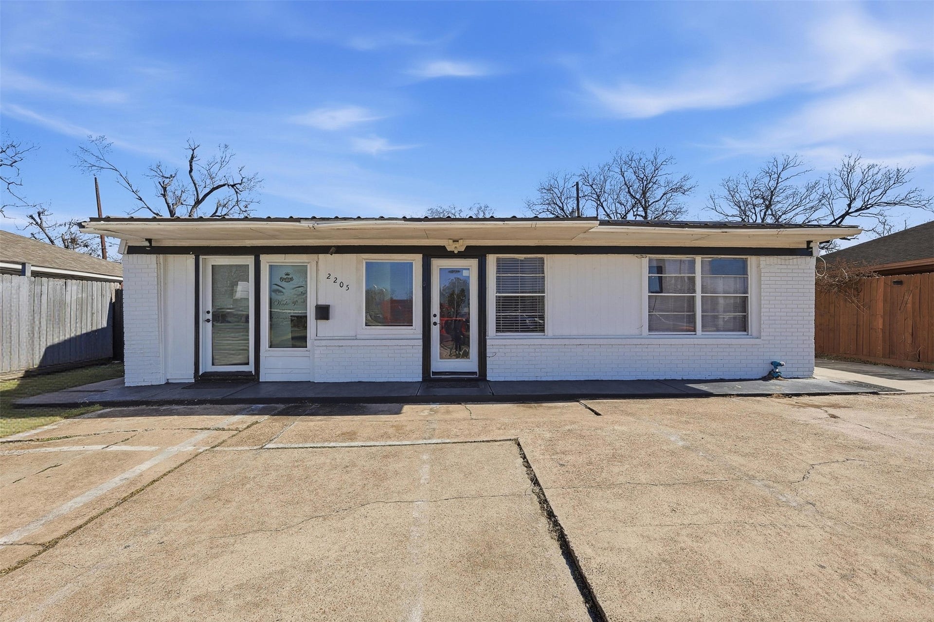 2205 Strawberry Road, Pasadena, TX 77502 Alternate front exterior view highlighting ample parking and dual entry access, offering flexibility for commercial or mixed-use operations.